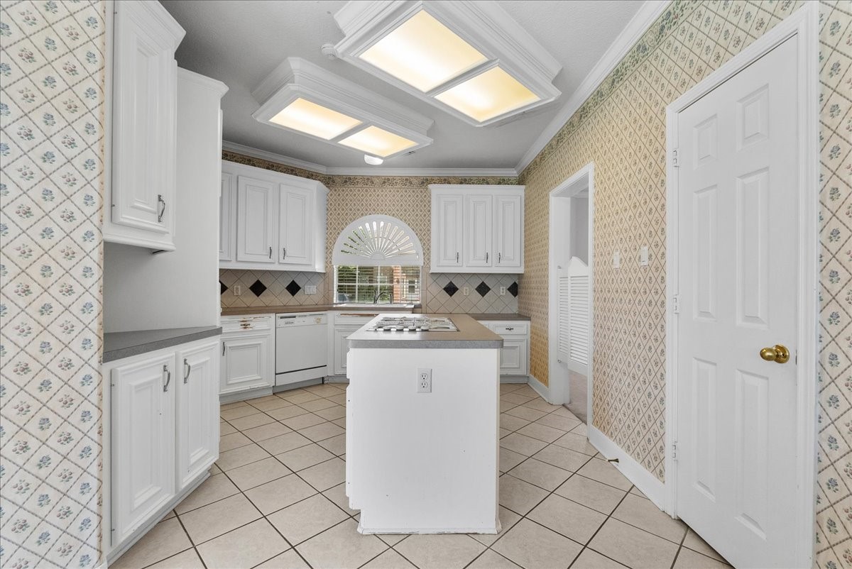 The central island with a built-in cooktop gives the home chef plenty of maneuvering room while keeping perimeter counters completely open.