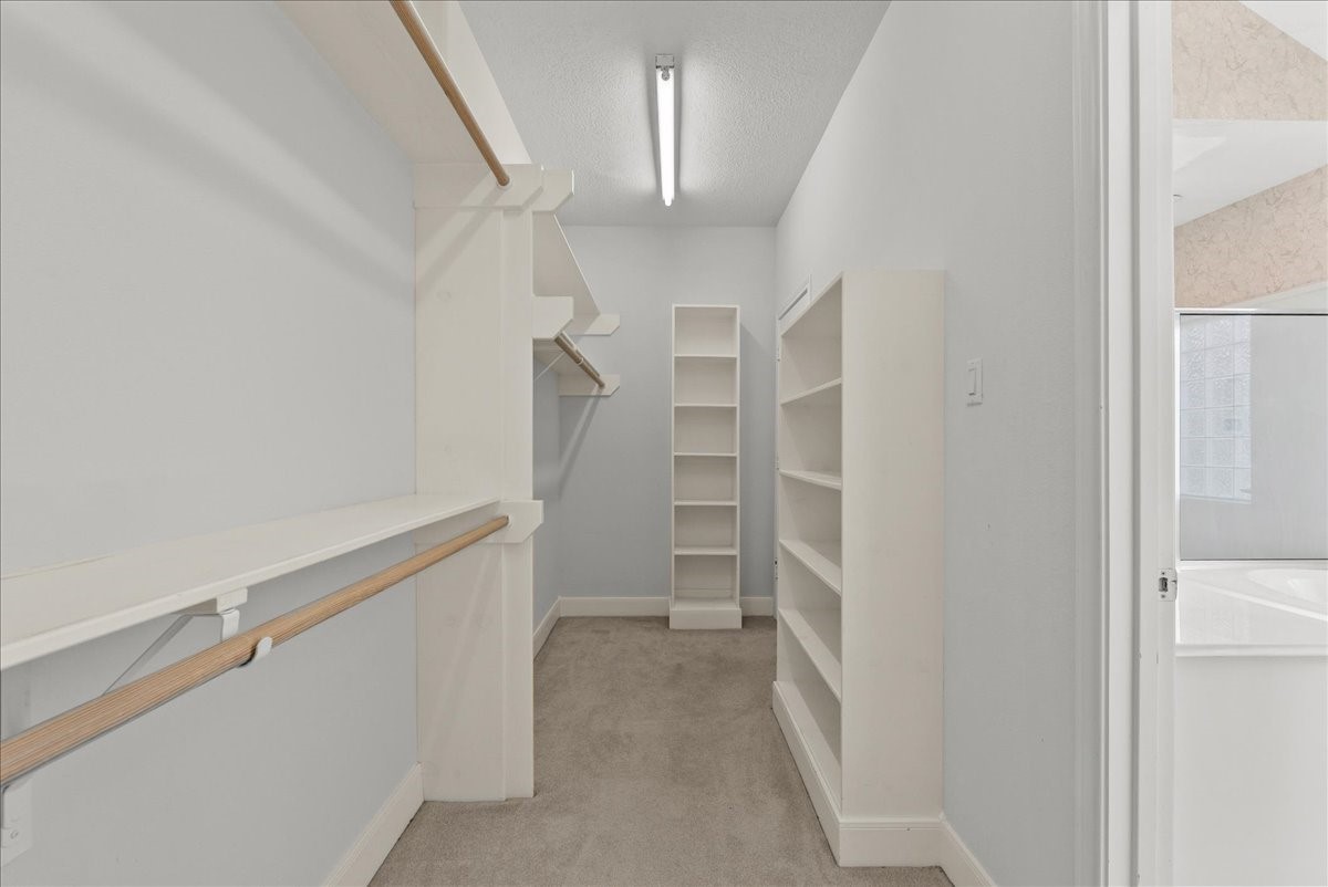 Custom floor-to-ceiling shelving units and tiered hanging rails maximize every square foot of storage.