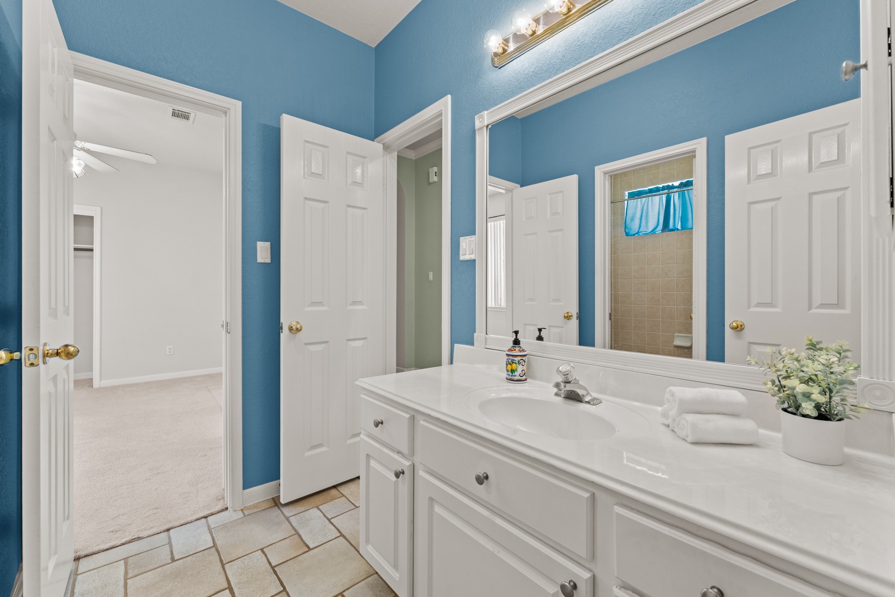 This fun, vibrant bathroom features a vanity area that is separate from the shower/tub area, making morning prep easier and more efficient!