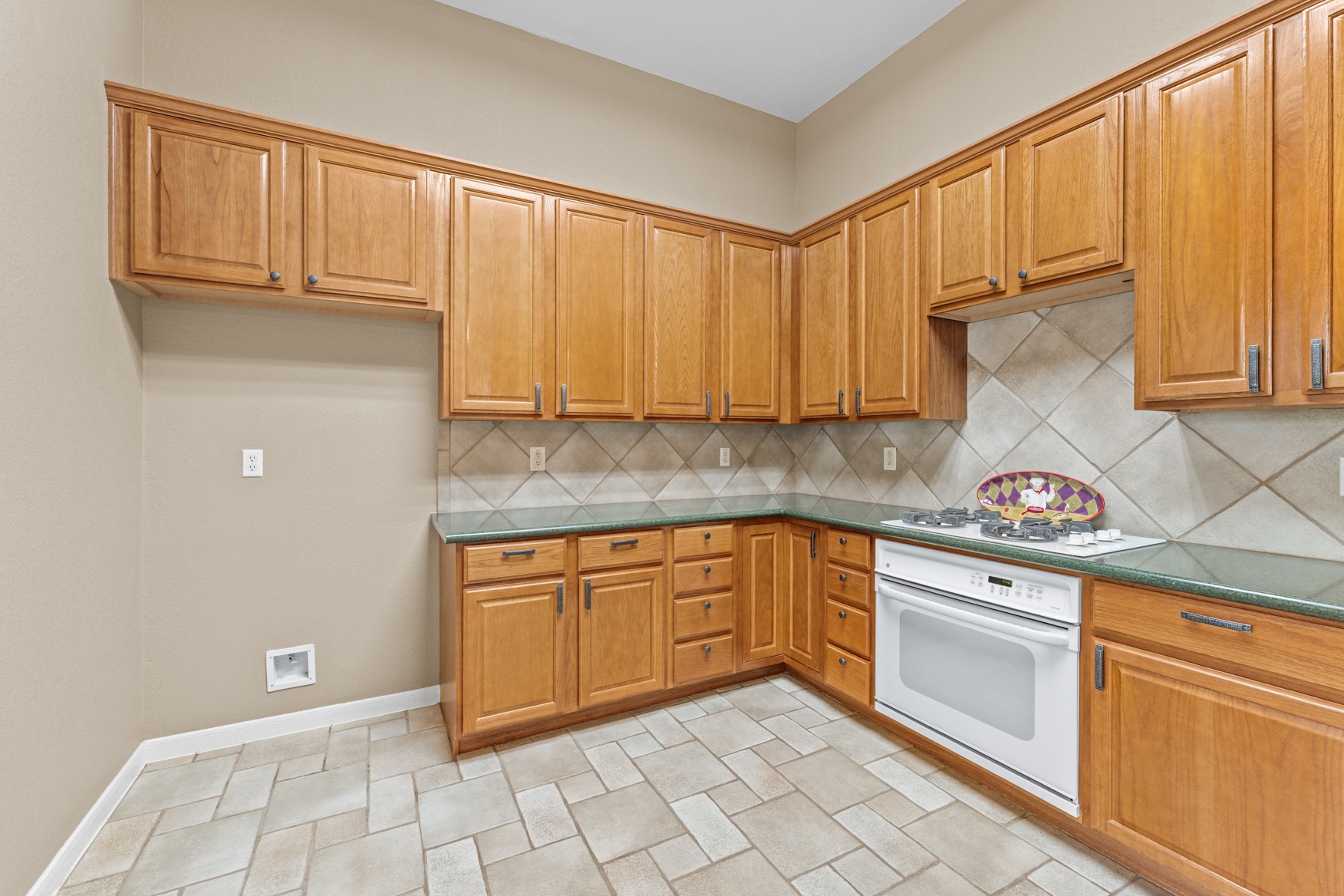 Beautiful 42-inch wood cabinets line the walls of the kitchen and hammered metal hardware adorn the drawers and cabinet doors.  Note the lazy-susan cabinet in the corner!