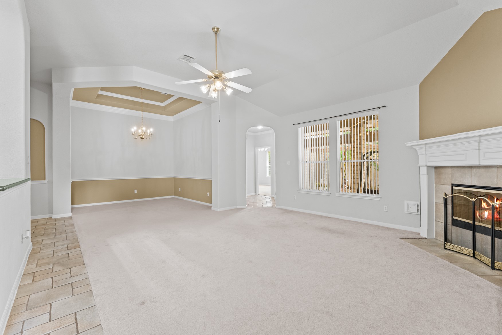 Smooth transition between the living and dining areas makes this space great for gatherings! The hallway right of center provides access to the back patio and to the primary suite.