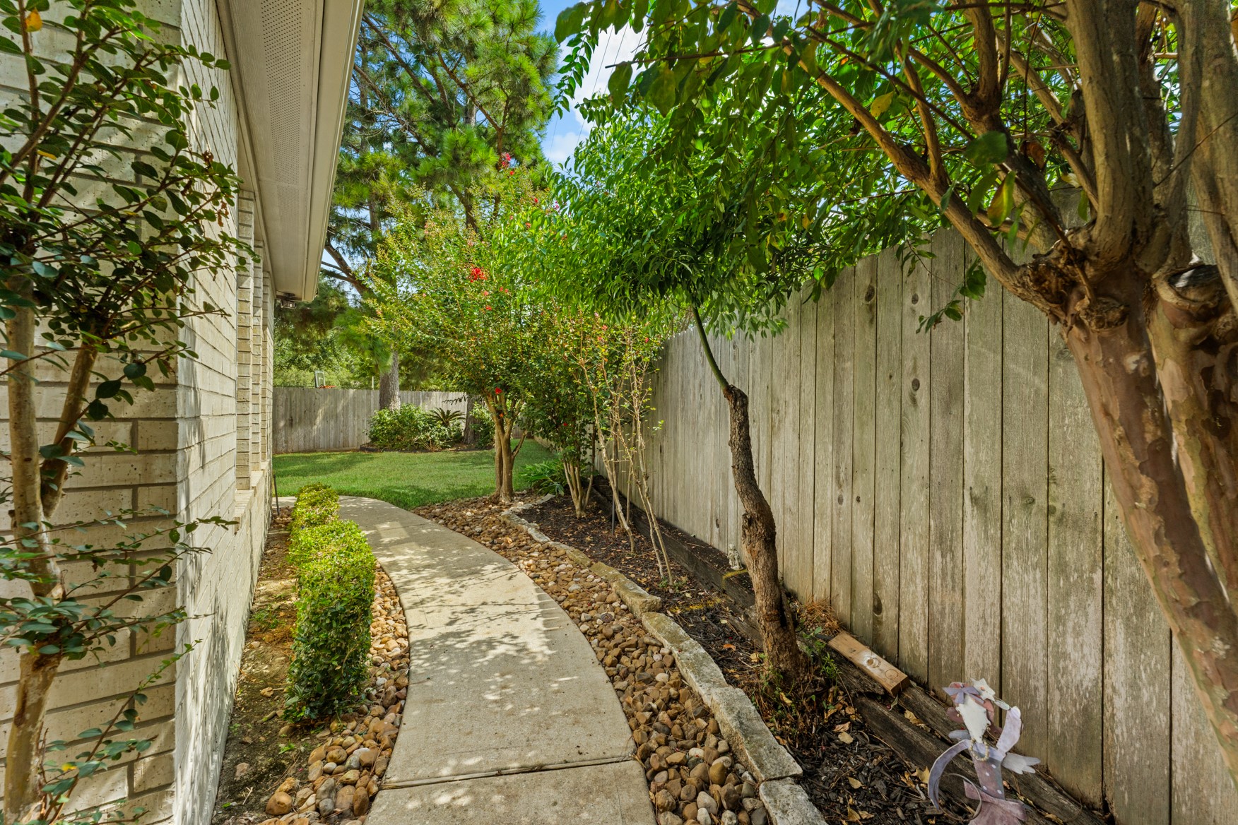 A rock-lined pathway leads to the other side of the house.