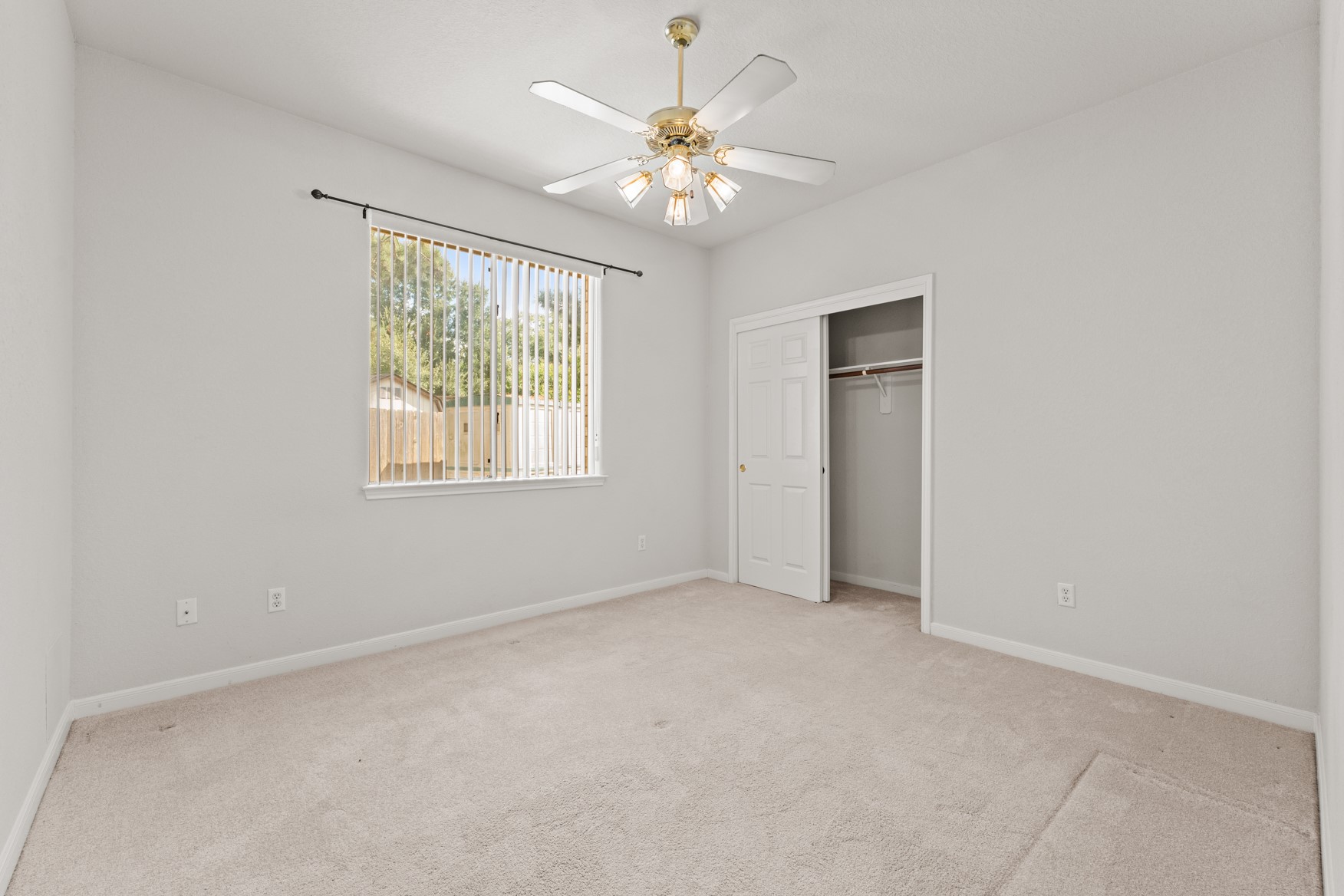 The second guest bedroom overlooks the wide side yard and offers privacy from neighbors.