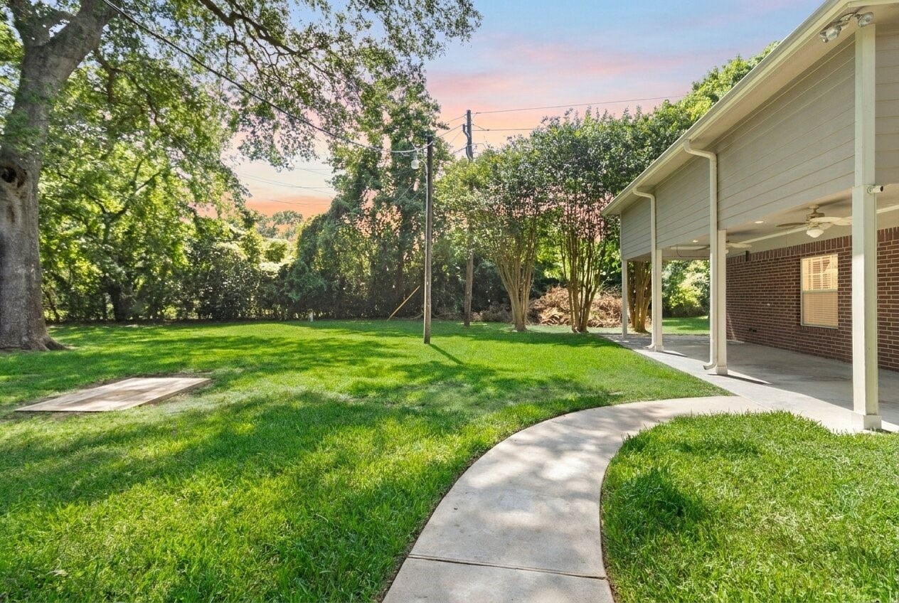 Follow the curved pathway through your private outdoor space where wide-open lawn areas & towering greenery create a calm, secluded setting.