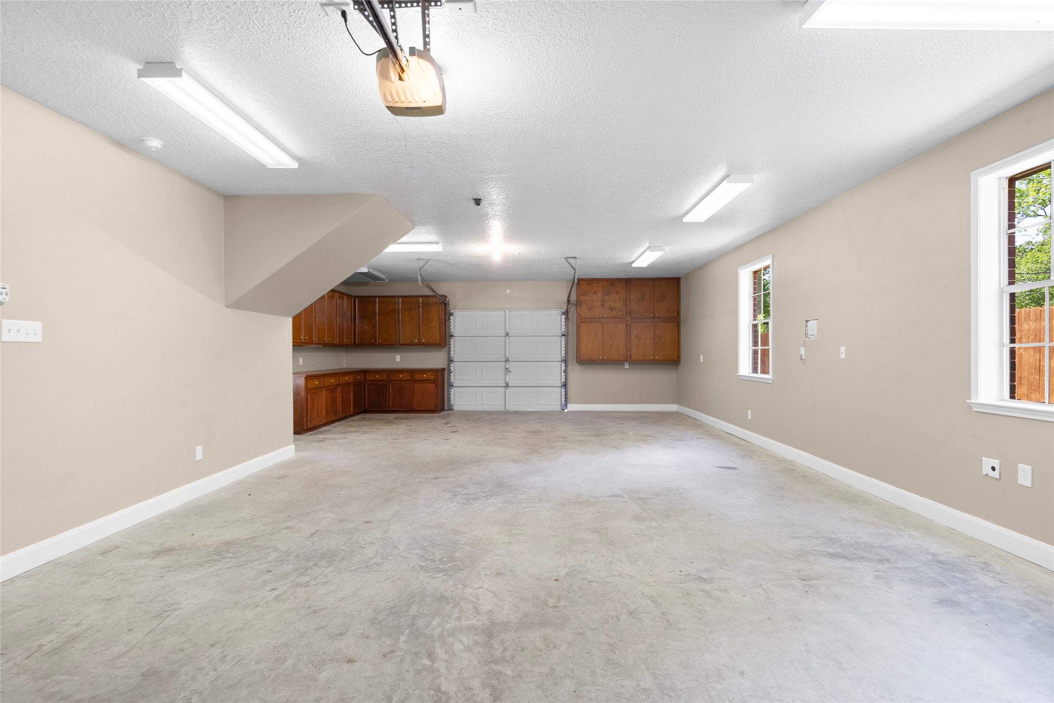 With generous room for vehicles, storage, tools, hobbies, or a workshop setup, this four-car tandem garage delivers the flexibility everyday life needs. Through access via a double-ended garage door makes loading and maneuvering easy, while insulated, sheetrocked walls and additional electrical hookups create a comfortable, functional space. A convenient half bath completes the setup.