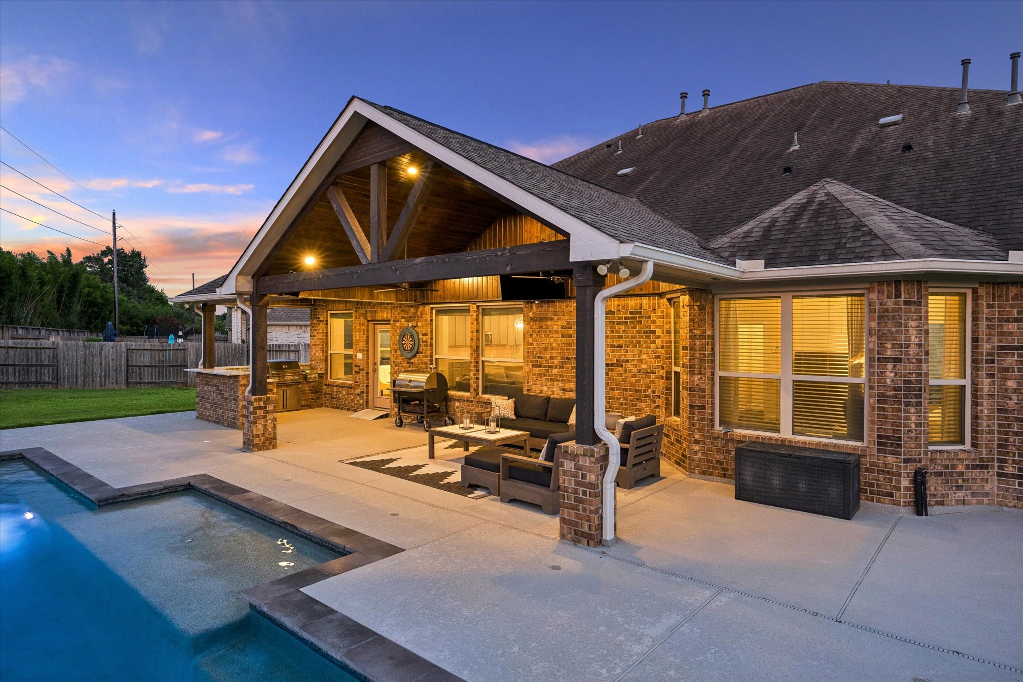 Extend your living space outdoors with this beautifully designed covered patio overlooking the sparkling pool. this exceptional backyard is designed for effortless indoor-outdoor living and memorable evenings under the Texas sky.