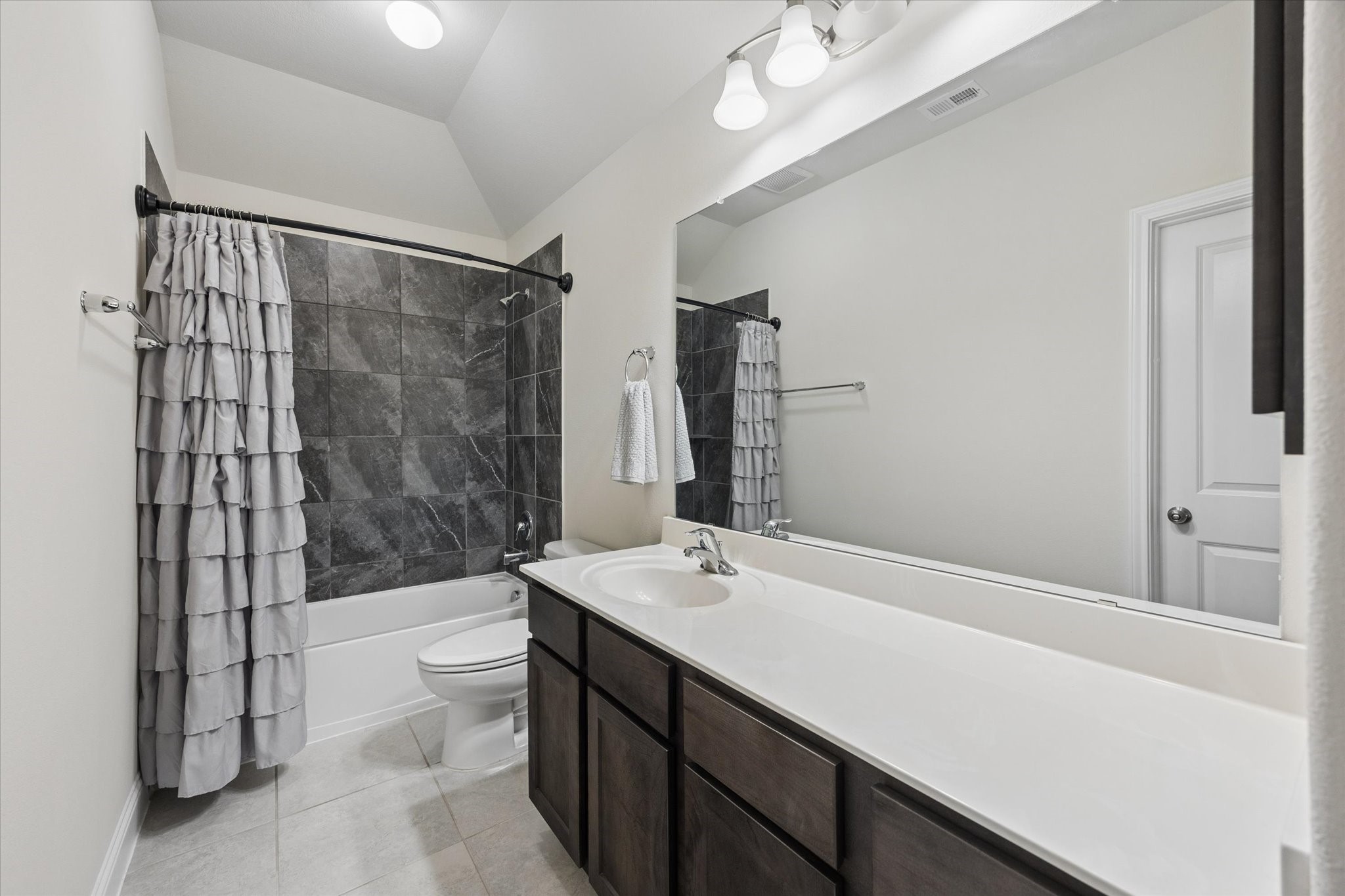 Private bathroom adjoined to secondary bedroom with plenty of a cabinetry and vanity room.