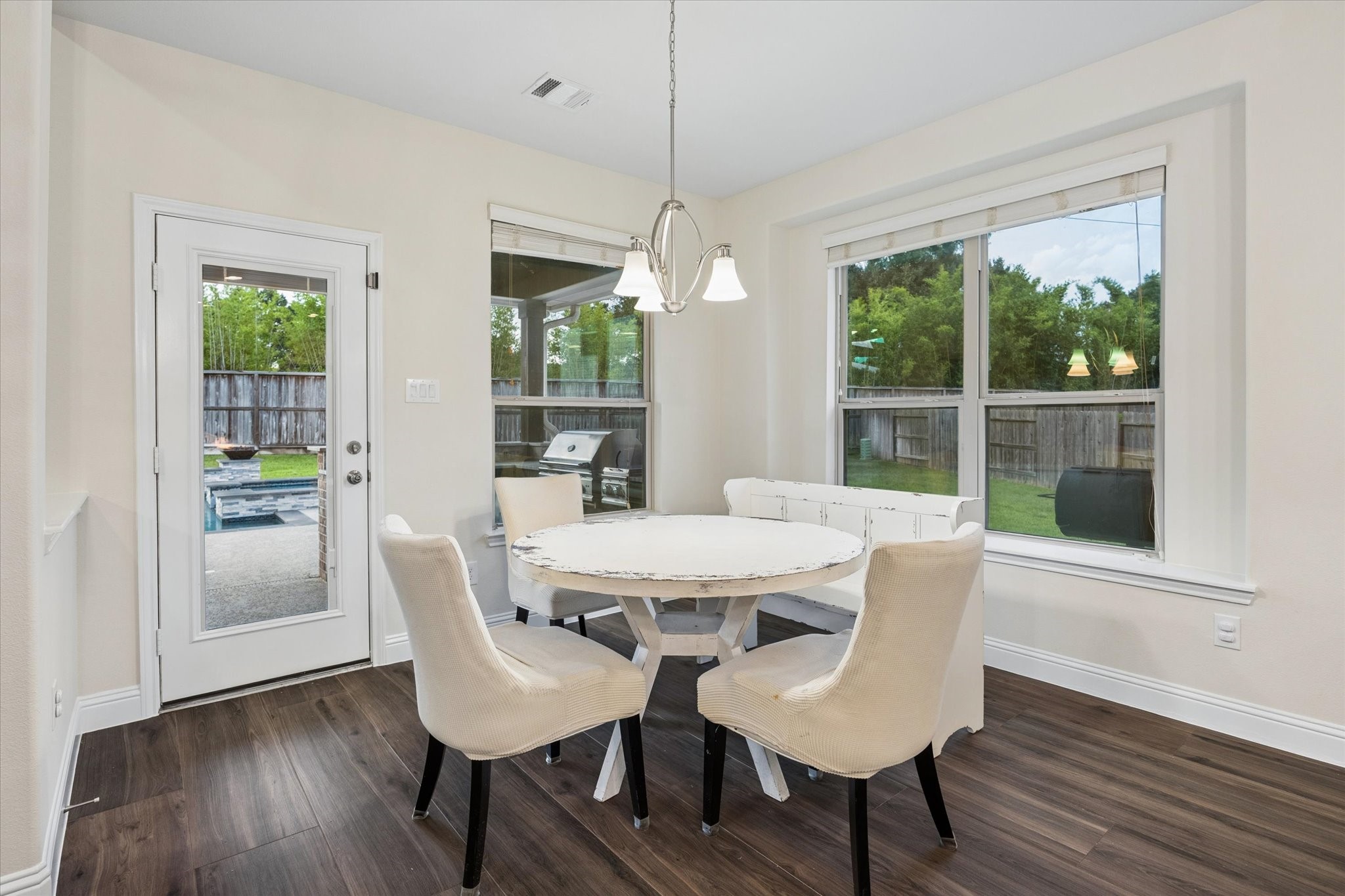 Bright and inviting breakfast nook with abundant natural light from large windows. A full glass-paneled door provides easy access to the backyard!