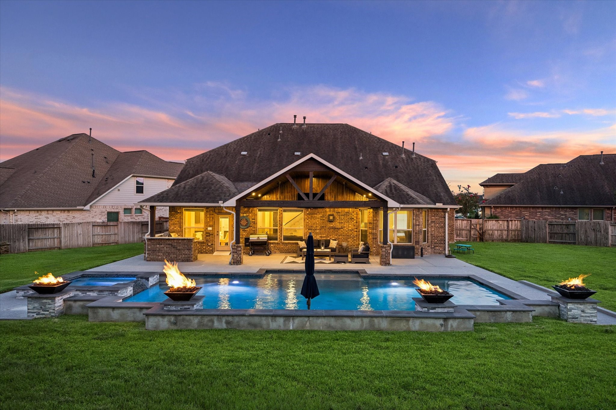 An extraordinary outdoor retreat awaits in this beautifully designed backyard, where resort-style amenities create an effortless setting for entertaining and relaxation. The expansive pool takes center stage, framed by multiple raised fire features that add warmth & ambiance!