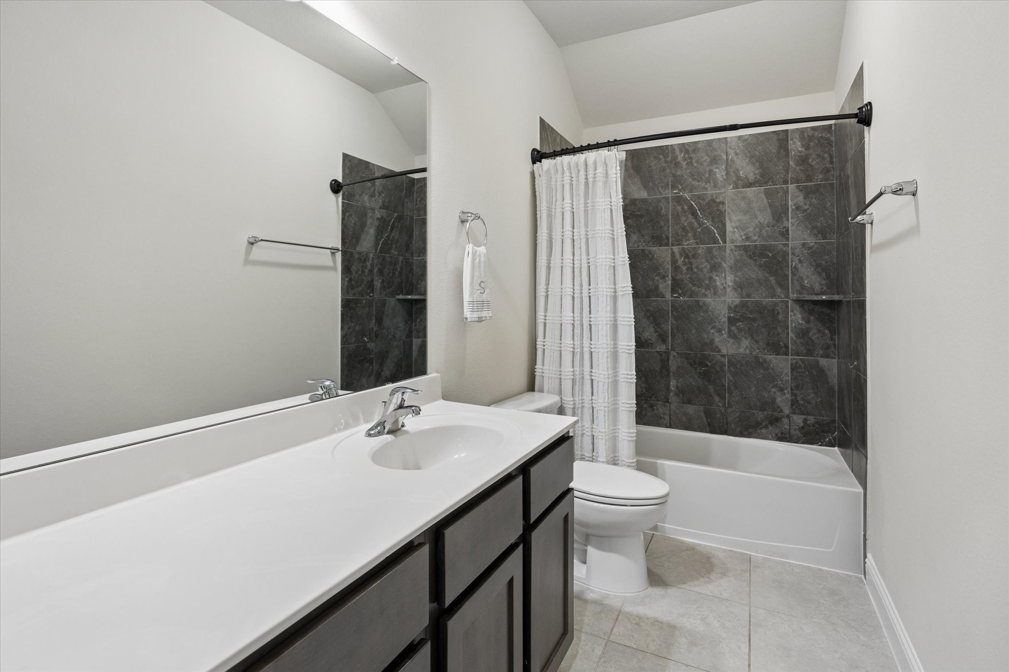 Secondary bathroom upstairs conveniently close to the game room with contemporary finishes. A crisp white vanity with ample counter space.