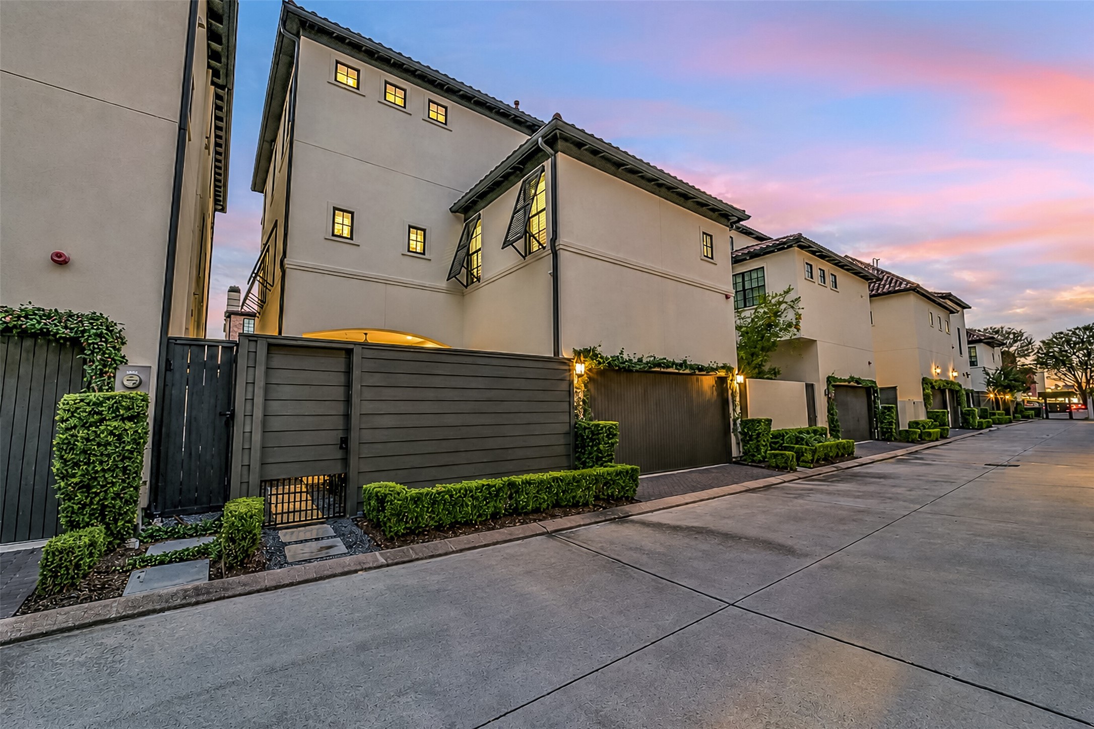 Easy rear access through a private alley, with a two-car garage and a gated courtyard for extra privacy. Neat hedges, climbing vines, and carriage lights give it plenty of curb appeal, and the stucco, tile roof, and shuttered windows add a touch of Mediterranean charm.