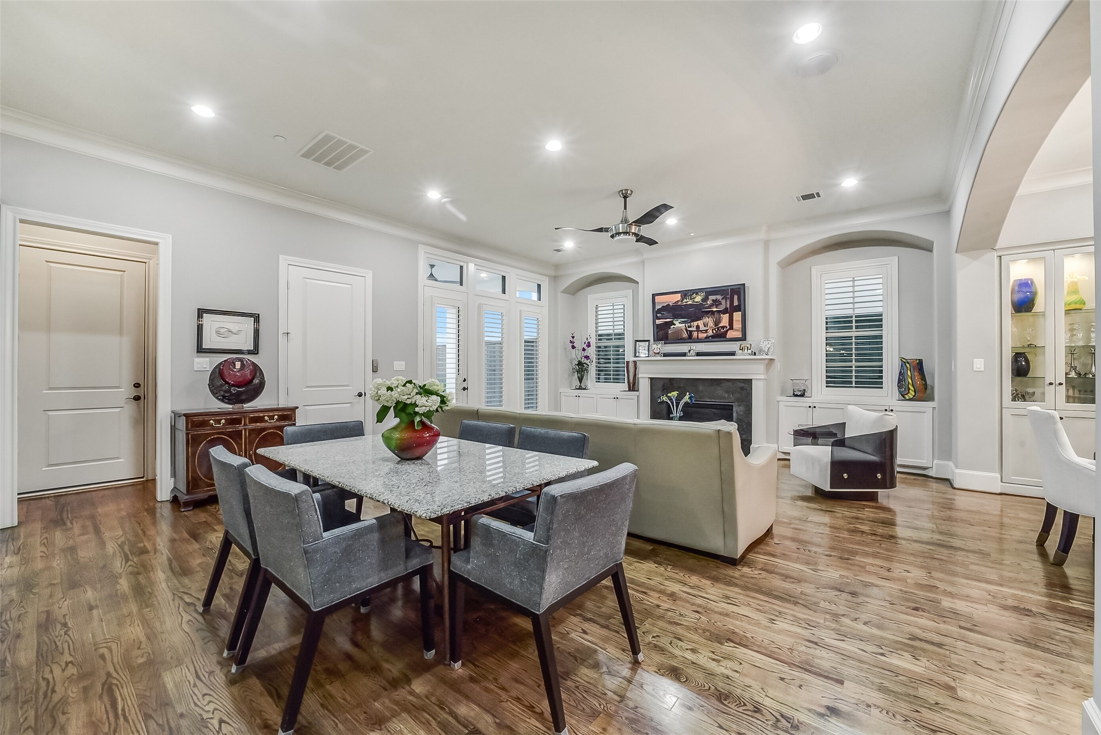 Perfectly positioned casual dining area between the kitchen and living spaces. This alternate view also showcases charming wood shutters and built-in cabinetry on either side of the living room fireplace.