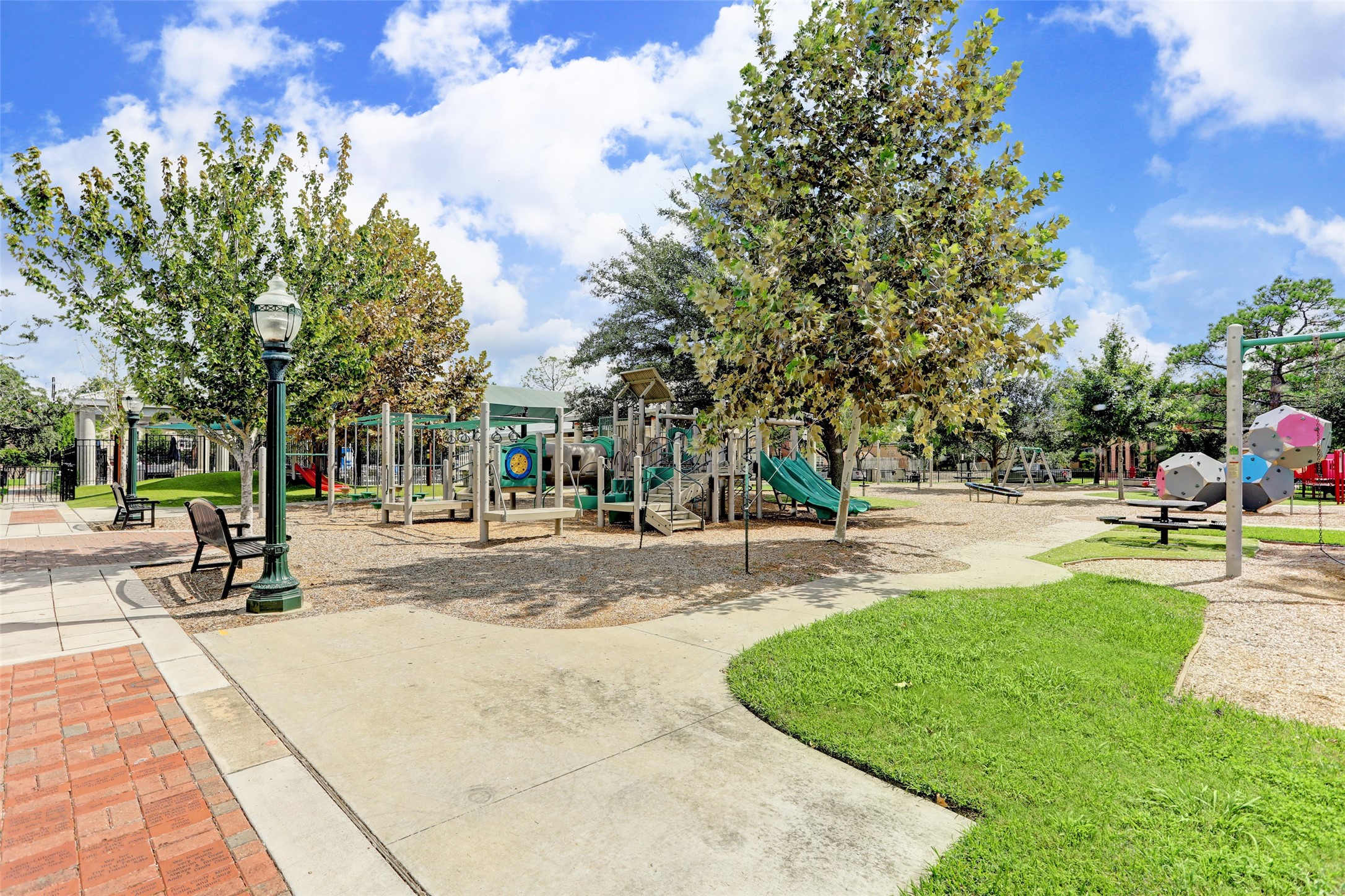 The neighborhood park featuring a playful fire truck theme, inviting green spaces, and a welcoming setting for families.