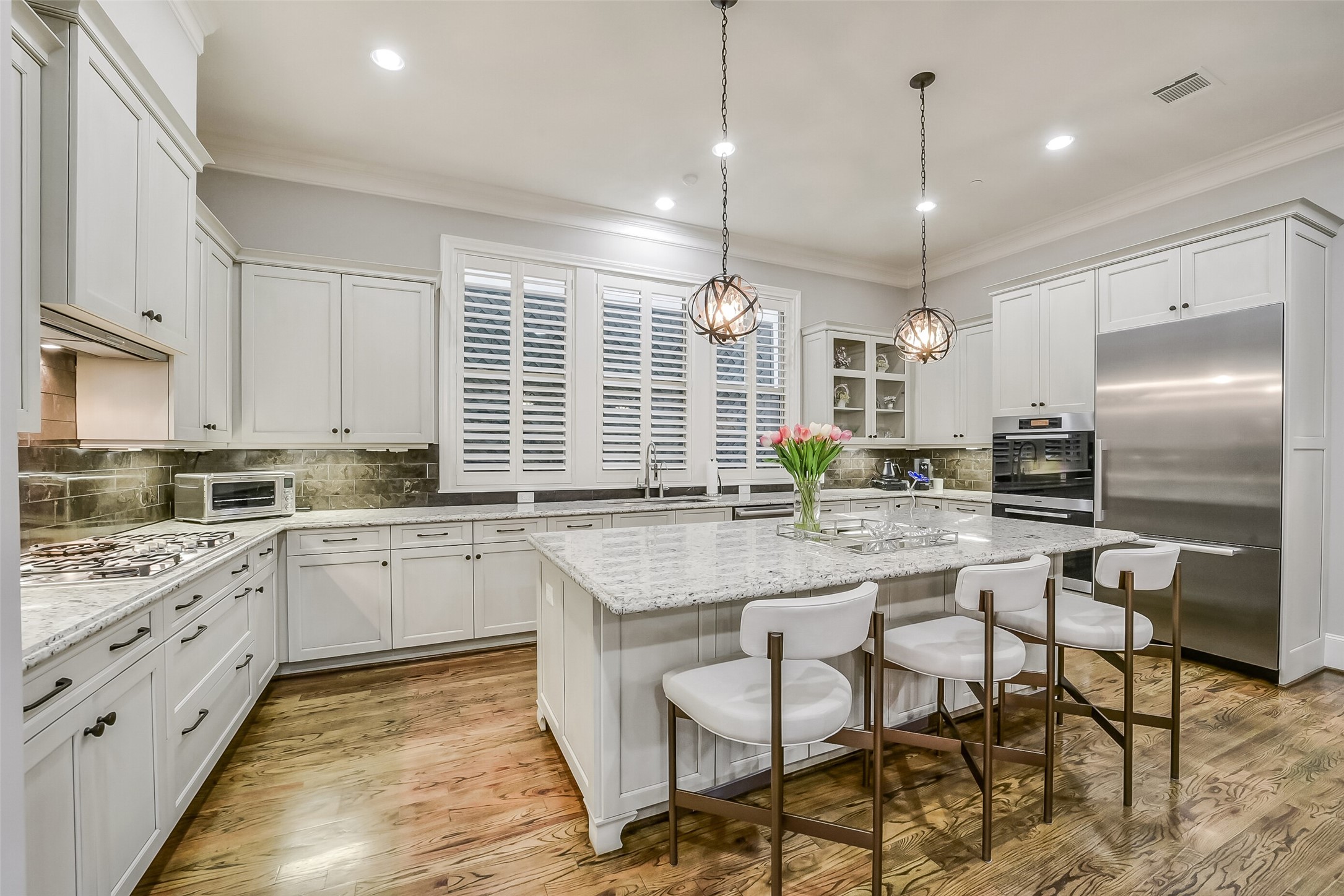 Alternate view of the gourmet kitchen highlighting the expansive layout. This culinary space is outfitted with premium Miele appliances including a speed oven.
