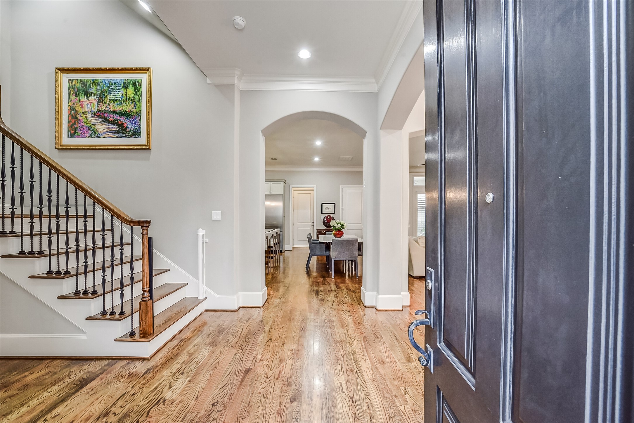 Rich hardwood floors and high ceilings highlight the grand entrance, leading seamlessly into the main-level living, dining, and kitchen areas designed for effortless entertaining. Rich hardwood floors and high ceilings highlight the grand entrance, leading seamlessly into the main-level living, dining, and kitchen areas designed for effortless entertaining.