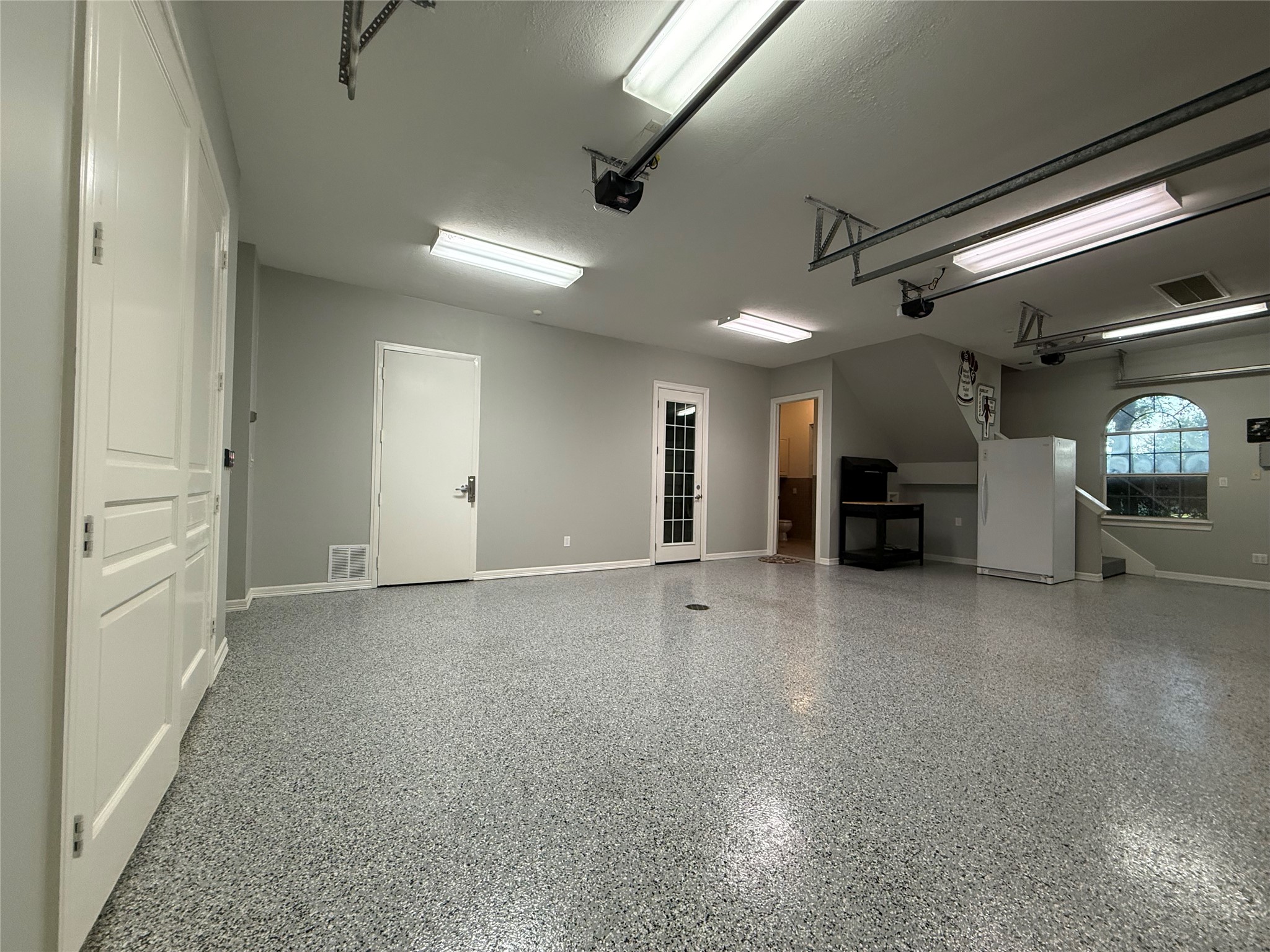 The 3-car, air-conditioned garage is far more than a place to park. Finished with durable epoxy flooring, bright overhead lighting, and recently replaced garage door openers on all three overhead doors, this space is ideal for car enthusiasts, hobbyists, or anyone needing a clean, versatile workspace. It also features a safe room and a full bathroom, adding both convenience and peace of mind. Whether you're storing a prized collection, creating the ultimate workshop.
