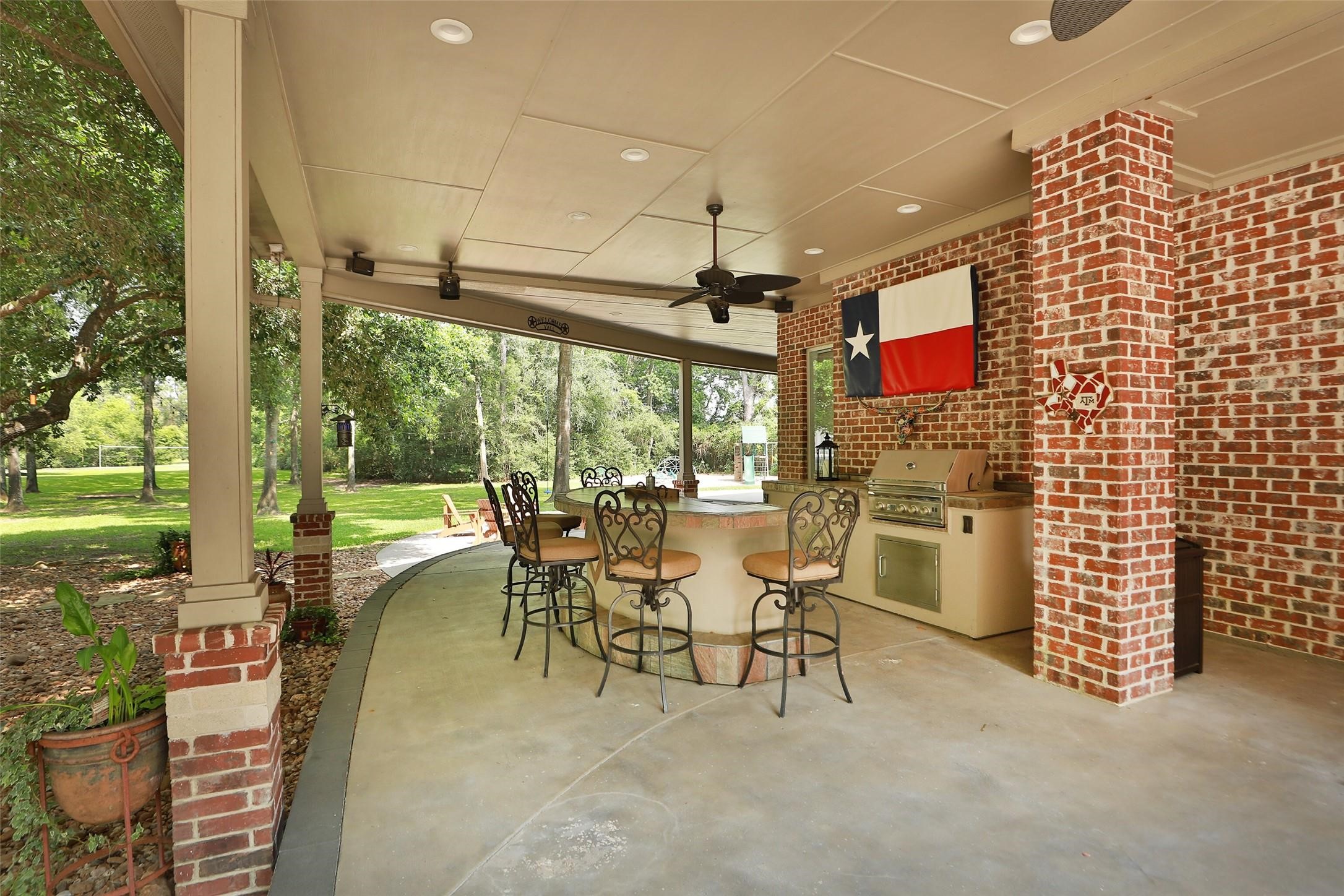 Outdoor entertaining at its finest! This incredible outdoor kitchen features a built-in grill, spacious bar seating, TV, beautiful lighting, and ceiling fans for year-round comfort. The perfect gathering place for family and friends to relax, dine, and make unforgettable memories!