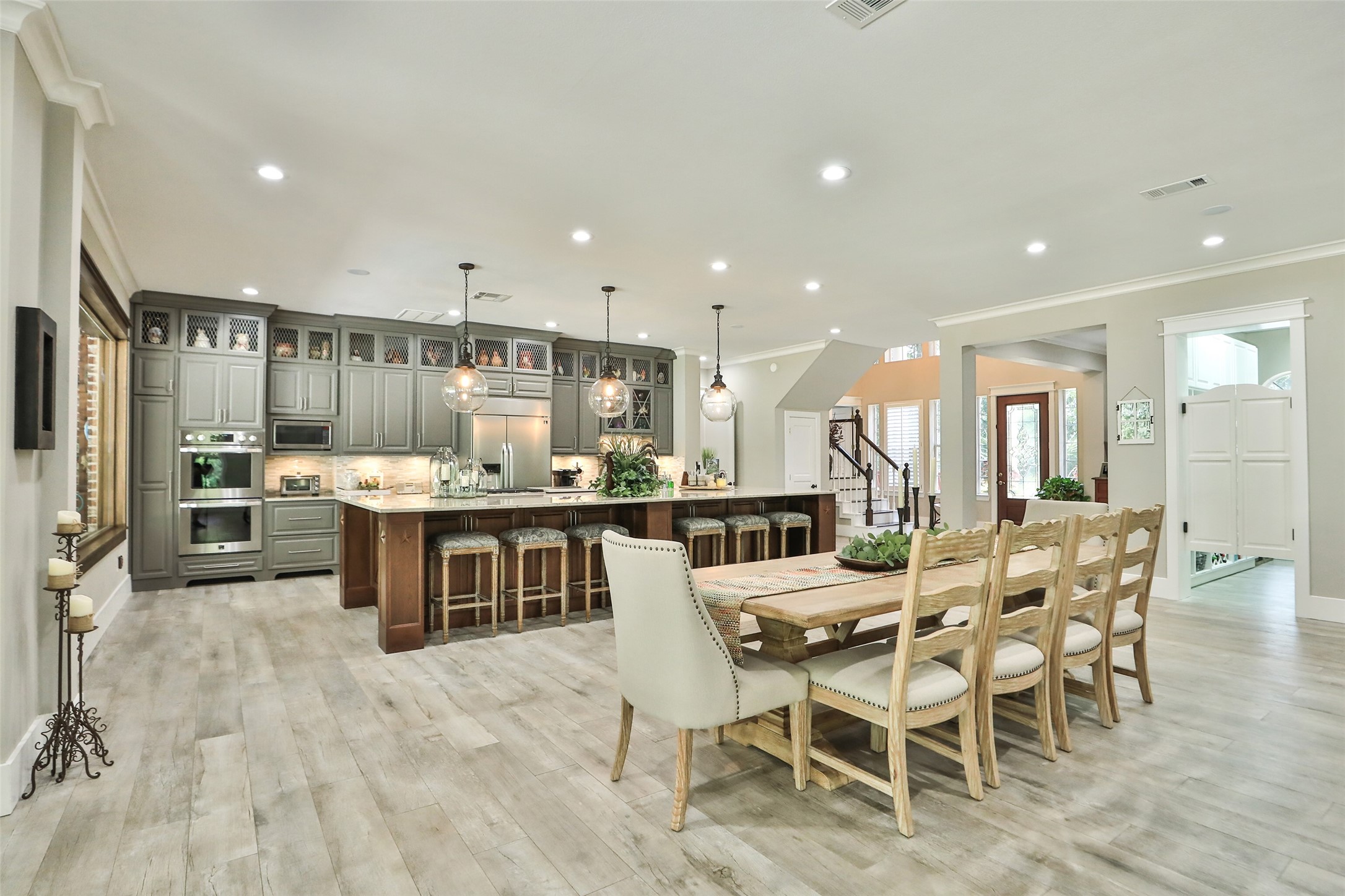 The Heart of the Home! This stunning open-concept kitchen and dining area features a spectacular oversized island, custom cabinetry, elegant pendant lighting, and beautiful wood-look tile flooring. Designed for effortless entertaining and memorable gatherings!