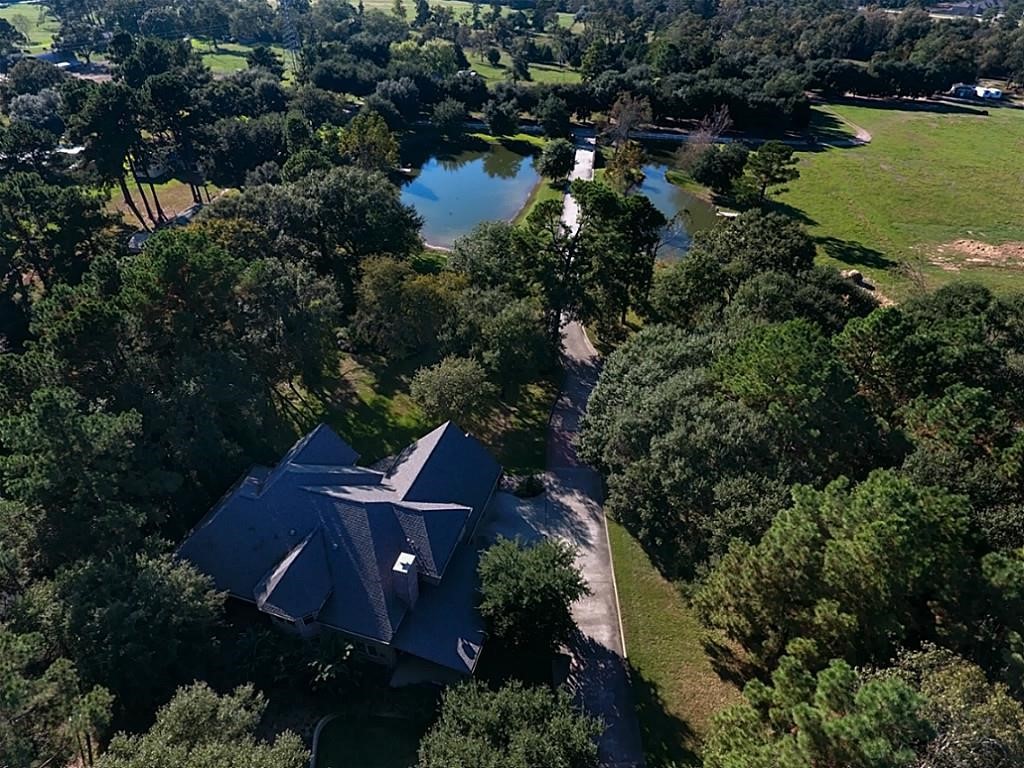 Aerial view of the house and pond with the long driveway. Look at all of the beautiful mature oak trees!