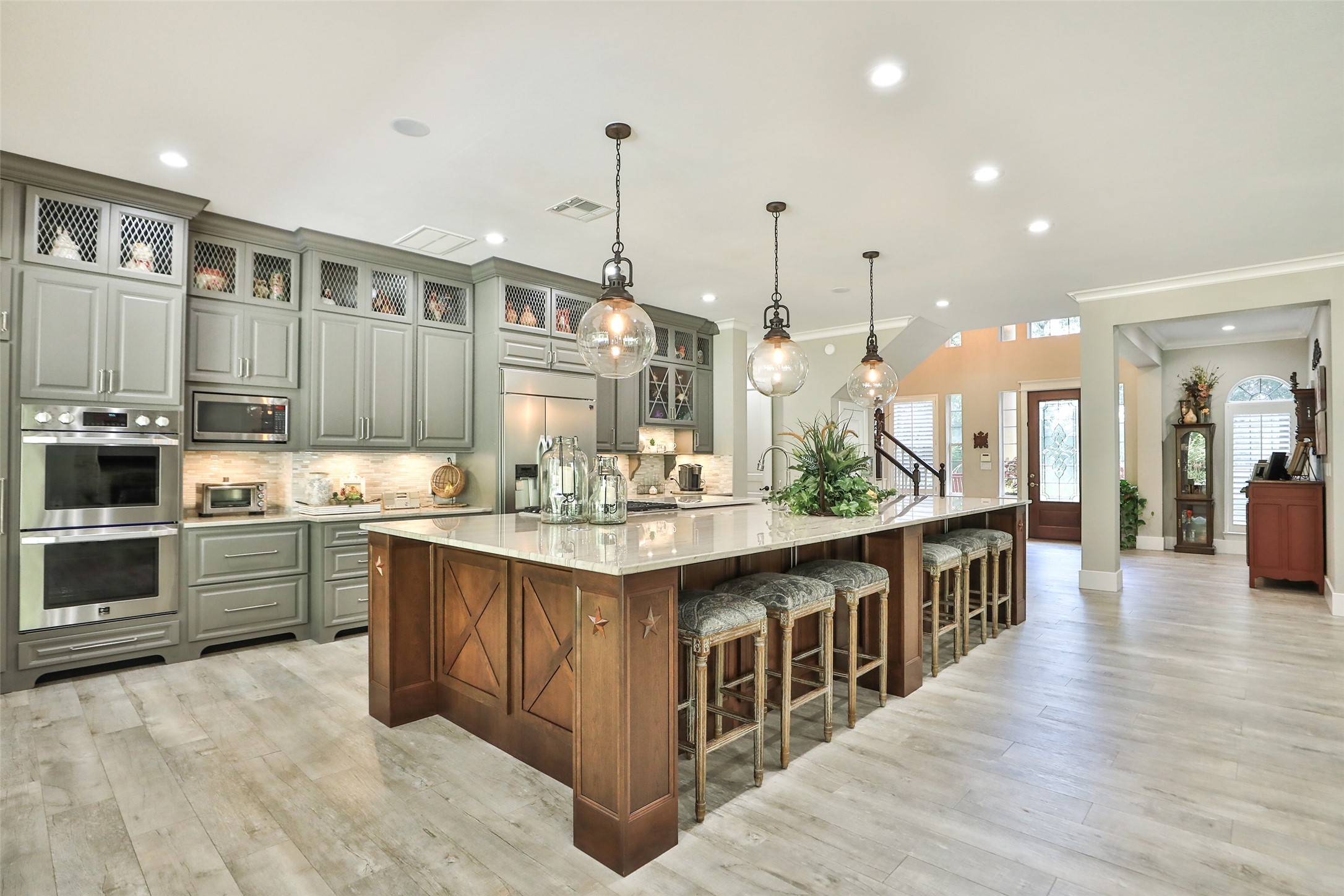 A Kitchen That Truly Steals the Show! This spectacular custom kitchen is an entertainer's dream, featuring an impressive 15' x 7' island with gorgeous quartzite countertops, beautiful custom cabinetry, LG Studio built-in appliances, and elegant pendant lighting.