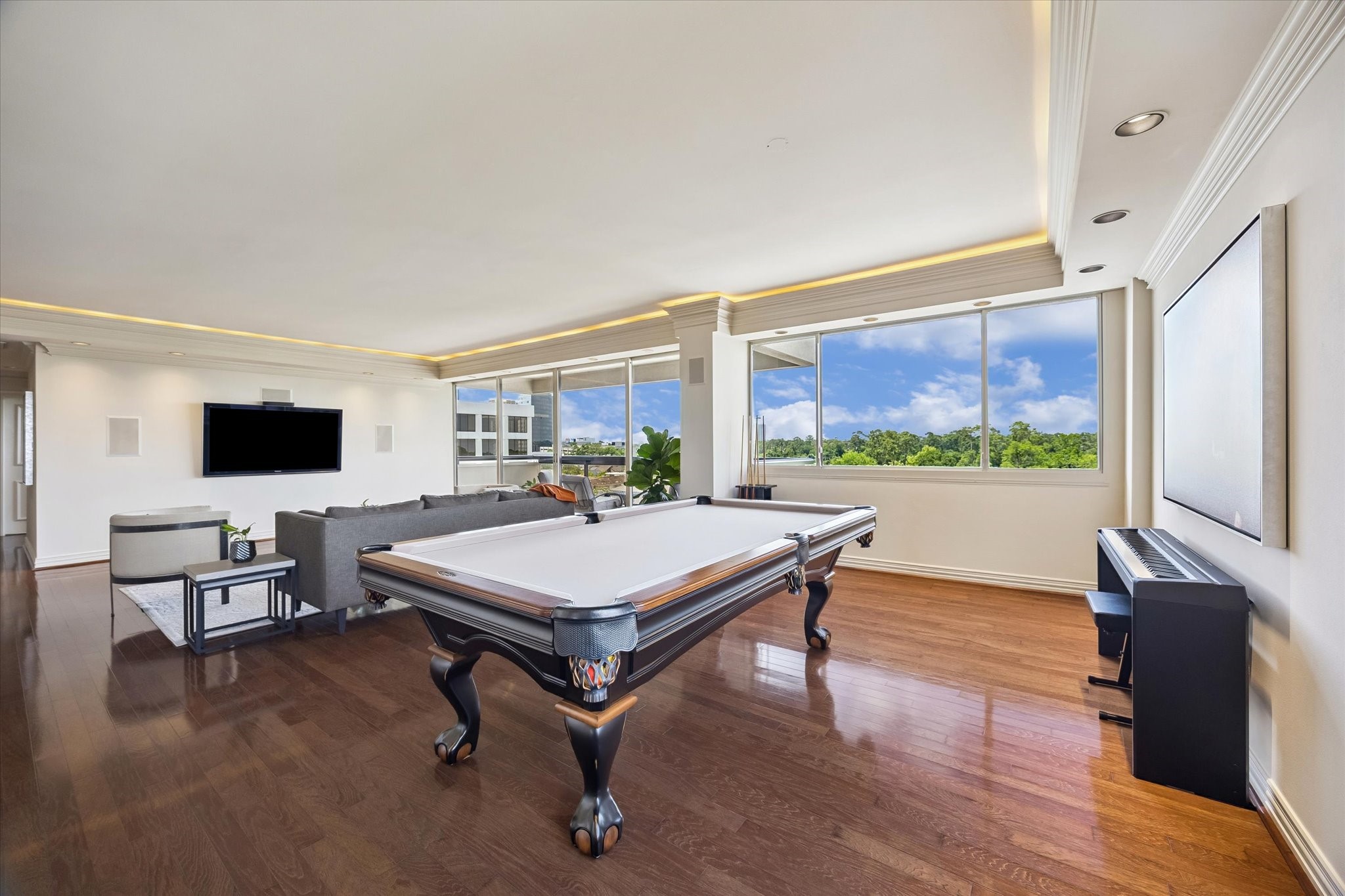 Formal dining space, currently being used a game room with huge windows and verdant, cerulean views.