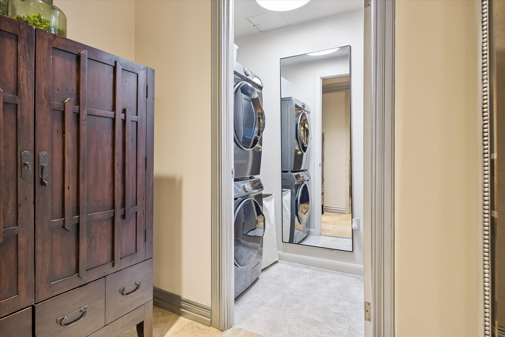 Utility closet with full sized, stacked washer and dryer.