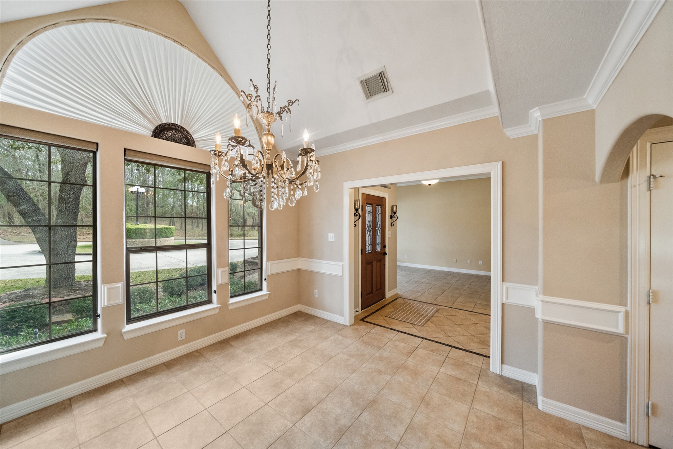 Formal dining features large windows for abundant natural light. Layout leads to adjoining kitchen, ideal for dining or entertaining.
