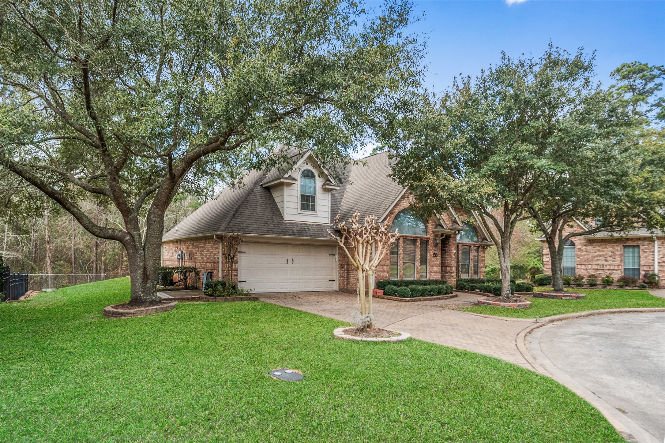 Charming brick home features a two-car garage and a welcoming entrance with large windows. Located in a serene neighborhood, perfect for family living.