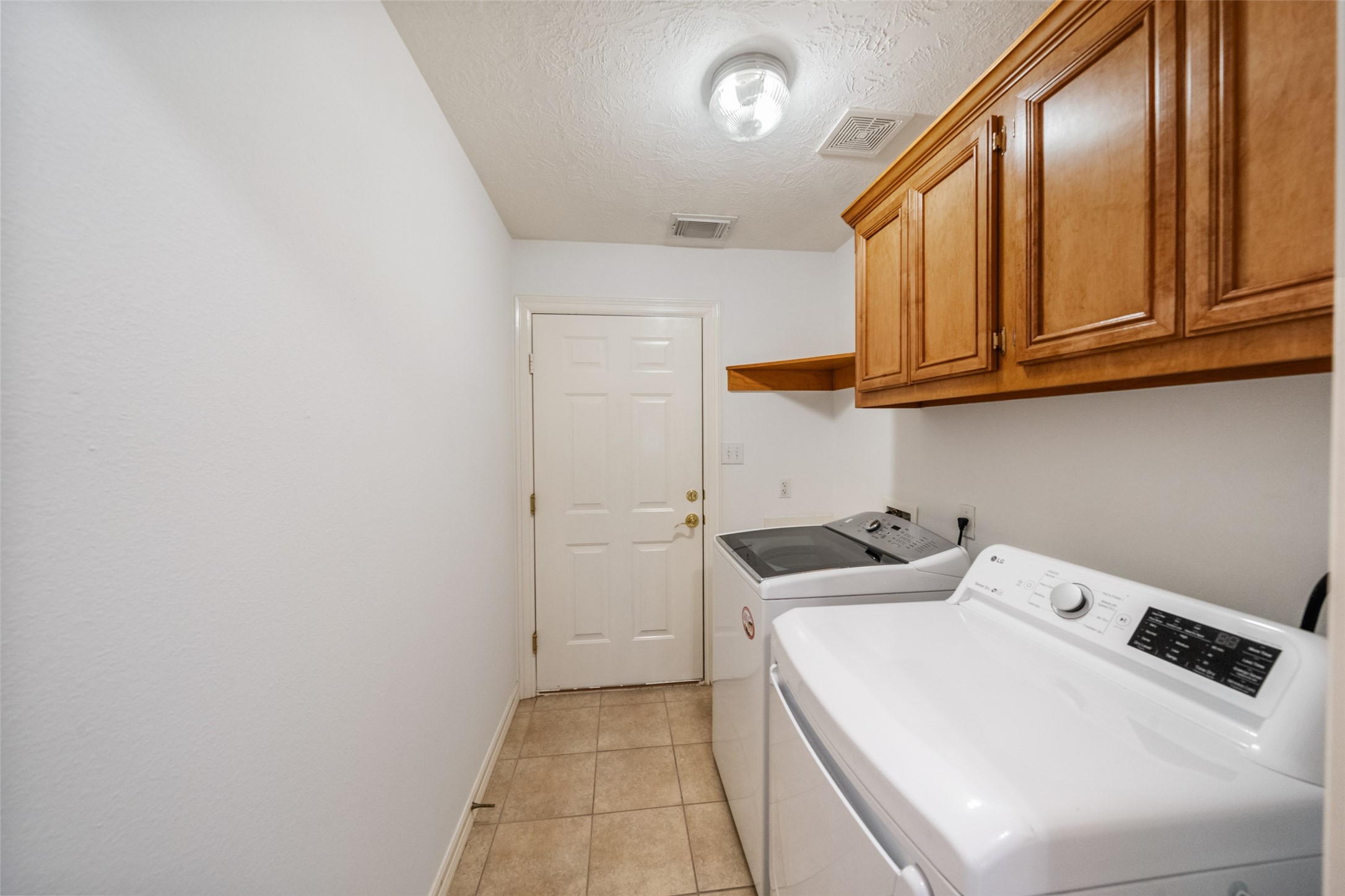 Laundry room leading to garage with cabinetry for ample storage.  Washer and Dryer are included.