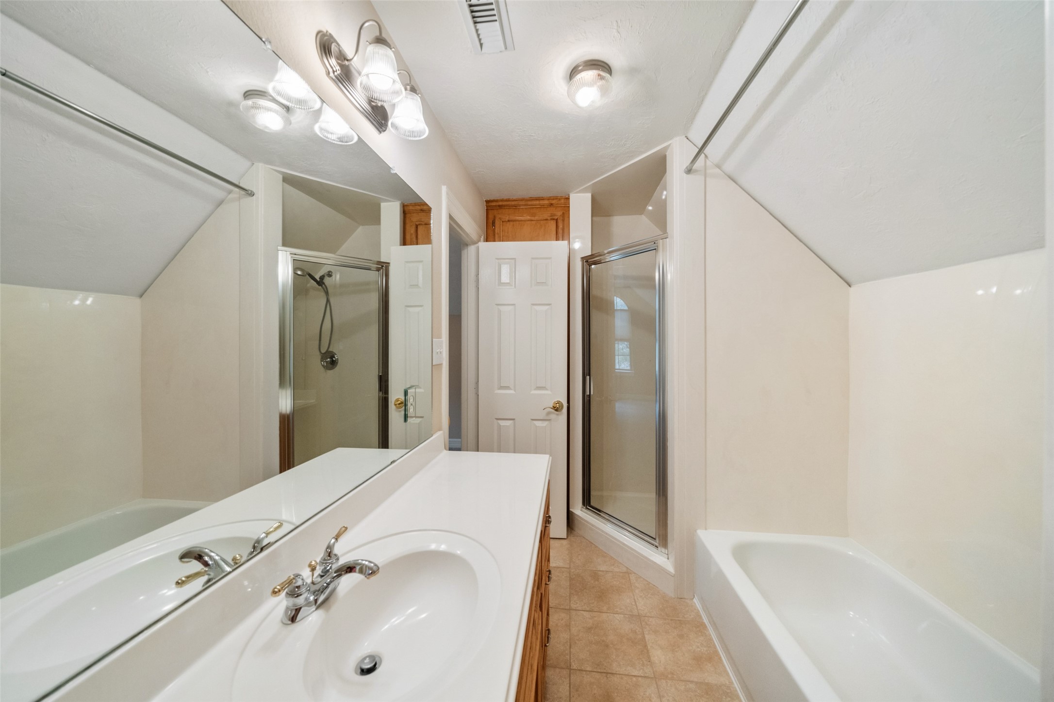Upstairs secondary bathroom features a clean, modern design with a separate shower, a bathtub, and a single-sink vanity.
