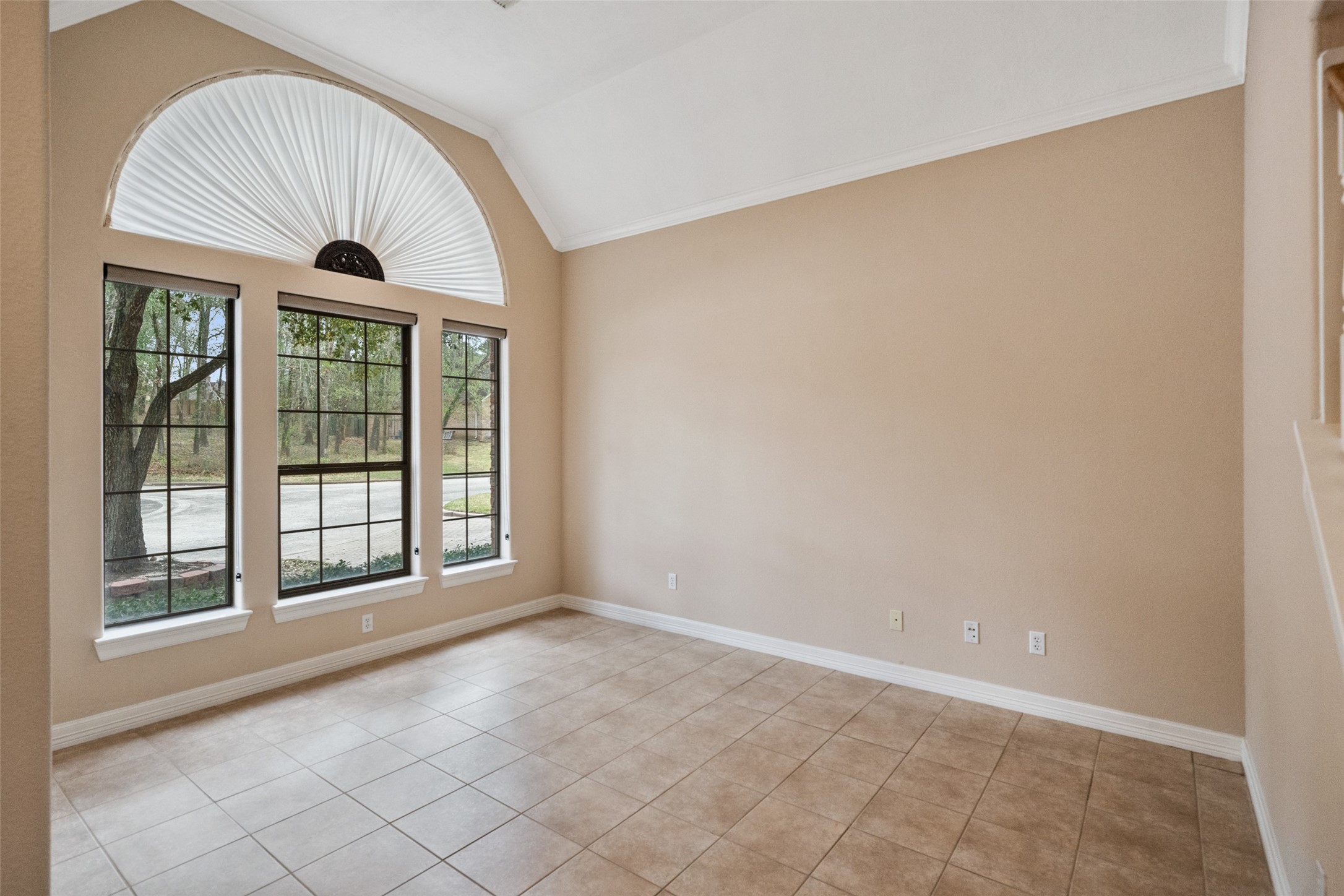 This formal living/home office features large windows with a semi-circular design, allowing ample natural light. It has neutral walls and tiled flooring, creating a bright and open atmosphere. This formal living/home office features large windows with a semi-circular design, allowing ample natural light. It has neutral walls and tiled flooring, creating a bright and open atmosphere.