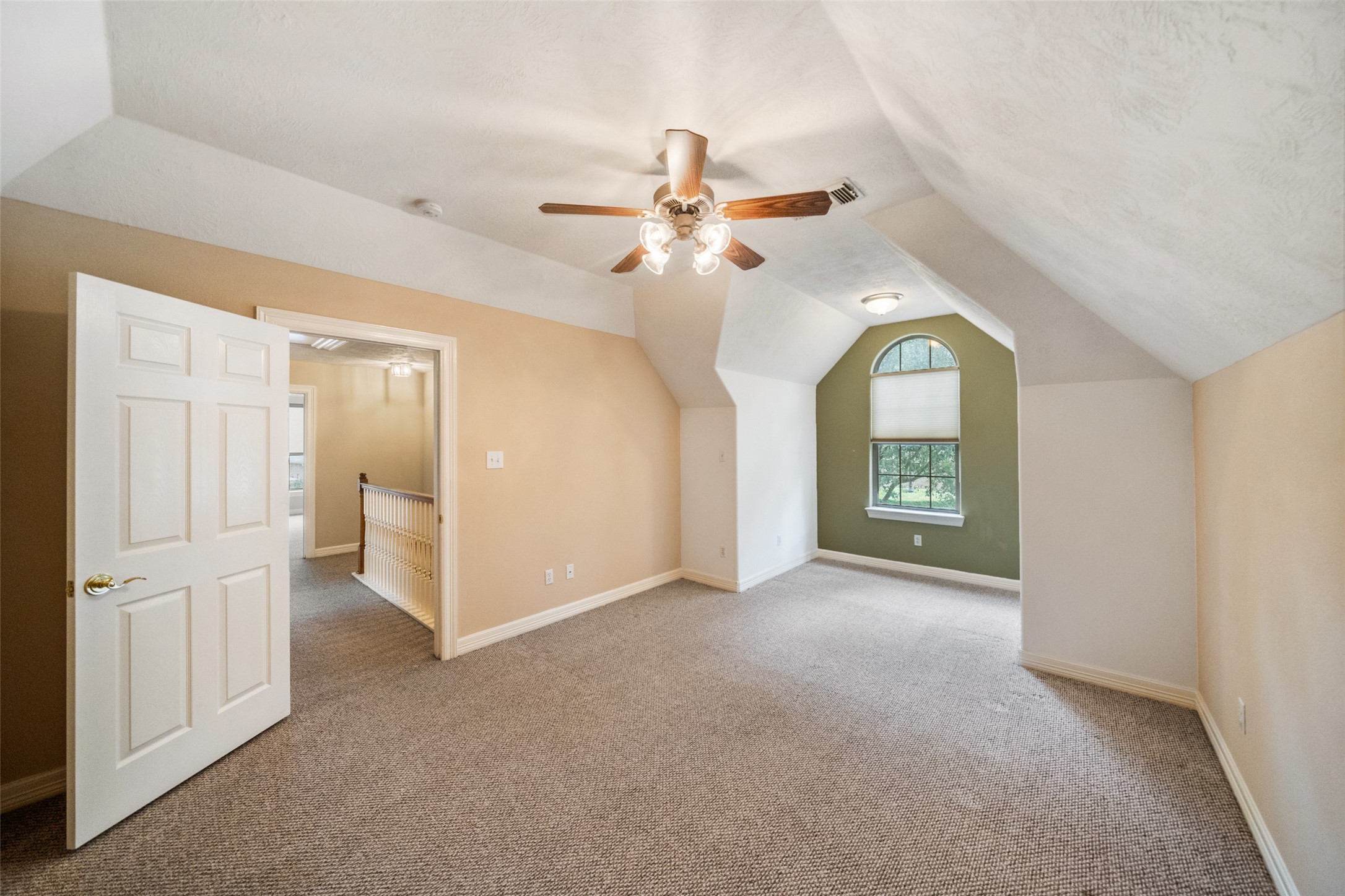Upstairs secondary bedroom is bright, spacious room with sloped ceilings, neutral walls, and carpeted floors. Ensuite bath with a spacious walk in closet.