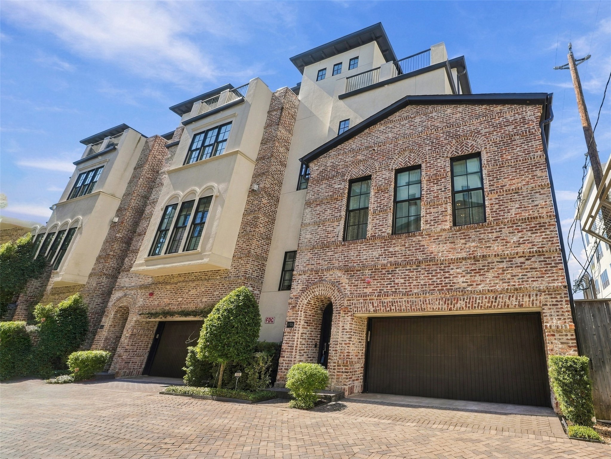 Four-story brick-and-stucco exterior with an attached garage tucked off the private drive. Four-story brick-and-stucco exterior with an attached garage tucked off the private drive.