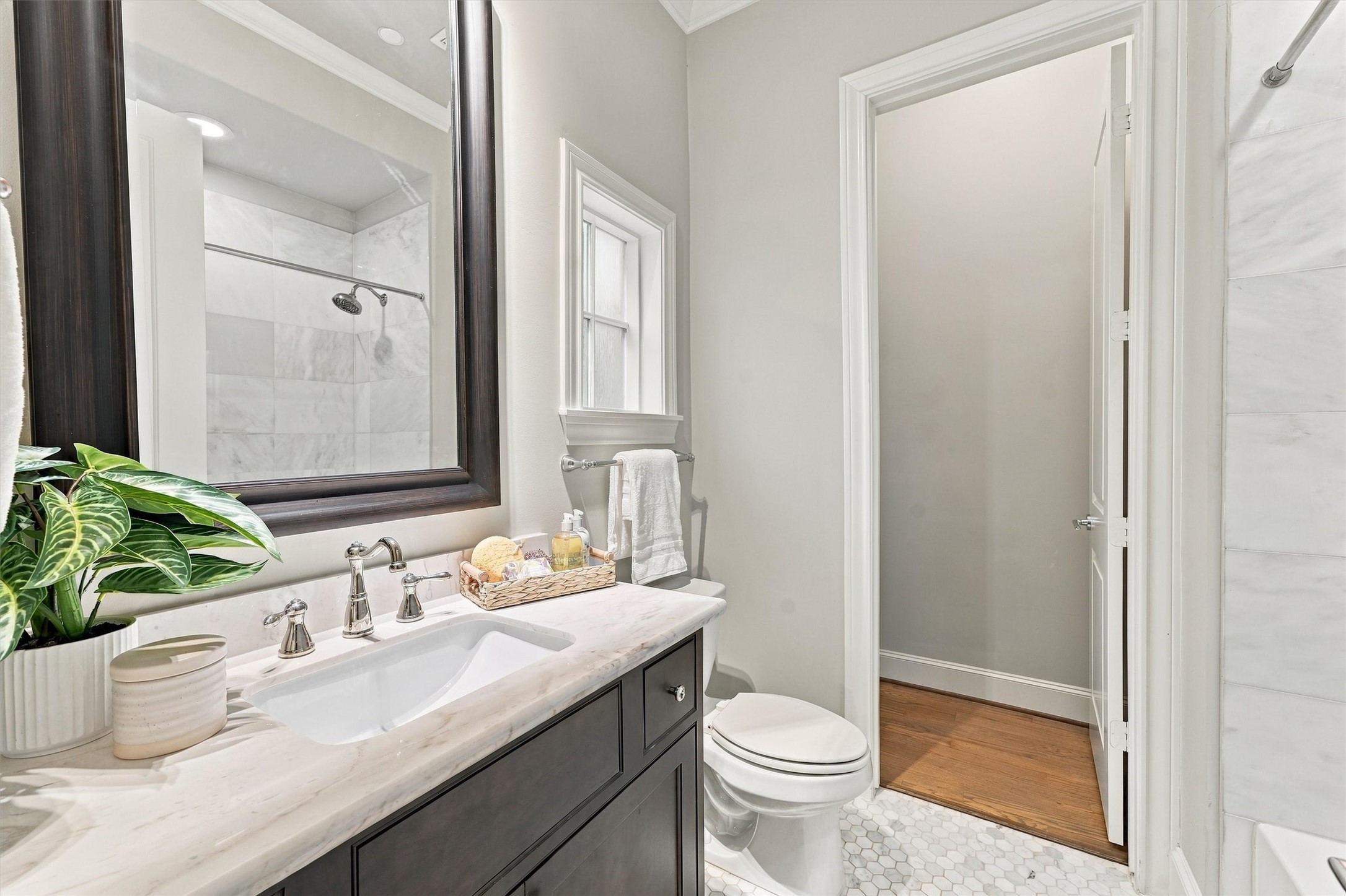 Guest bath with white marble, a hexagonal mosaic floor and polished-nickel fixtures