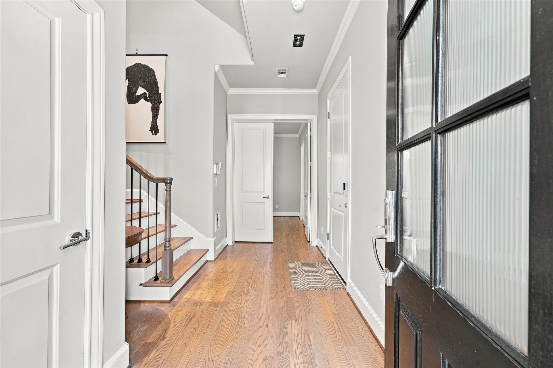 Entry hall with wood floors, crown molding and solid-core doors