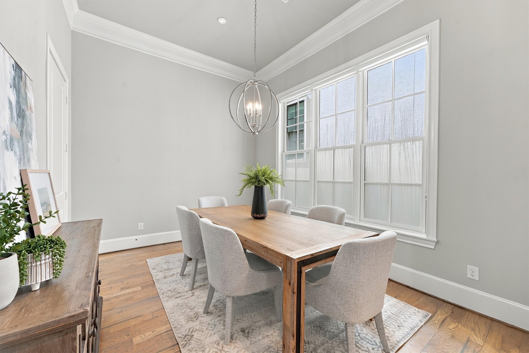 Dining area with an orb chandelier and a wall of divided-light windows