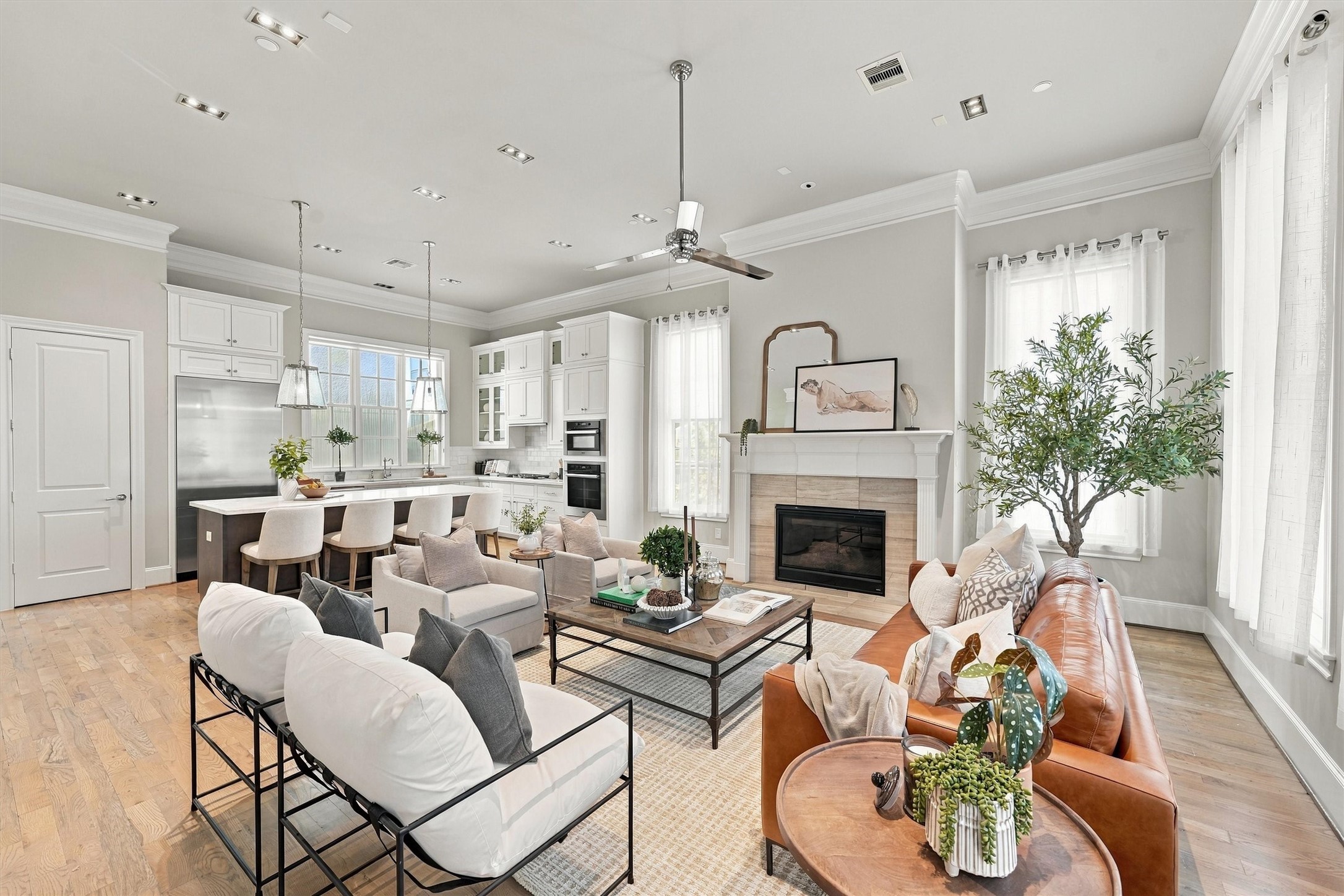 Open living level where the great room, kitchen and dining area flow together beneath tall ceilings