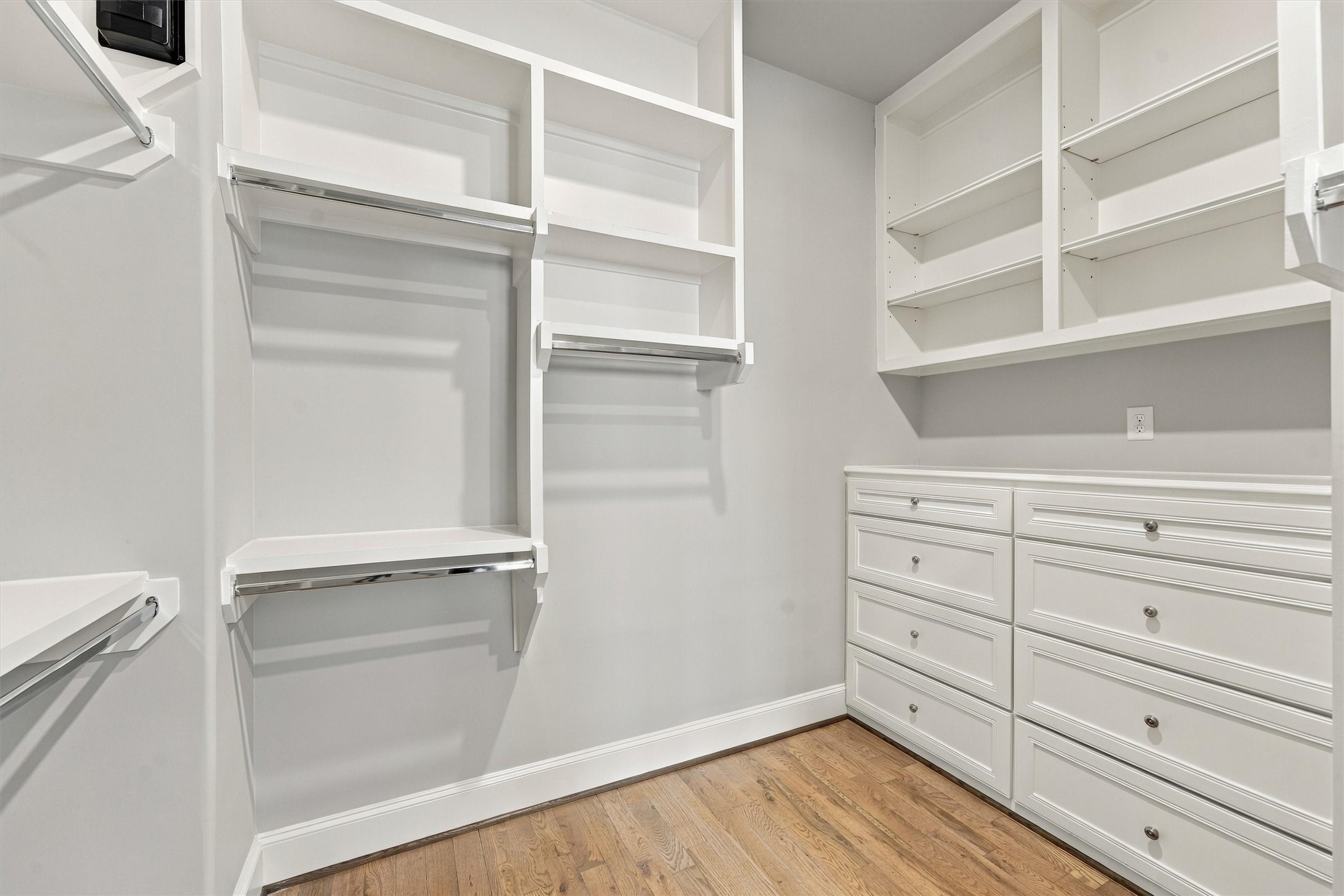 Primary closet with custom built-ins, double hanging and a full bank of drawers