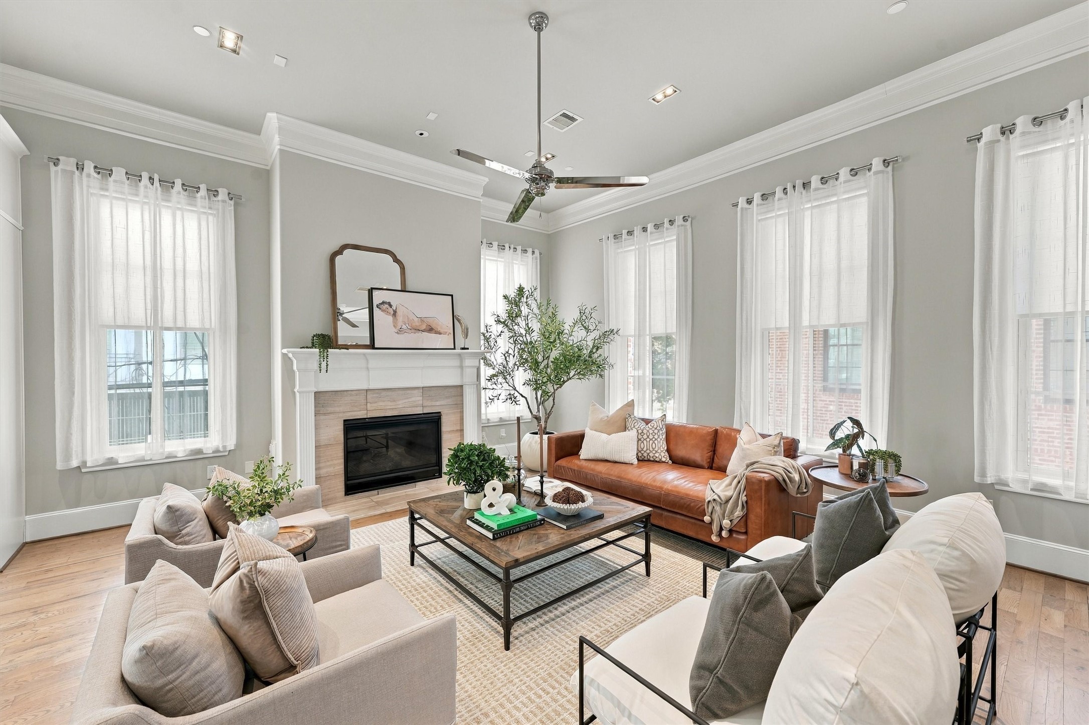 Great room with tall windows on two walls and a gas-log fireplace