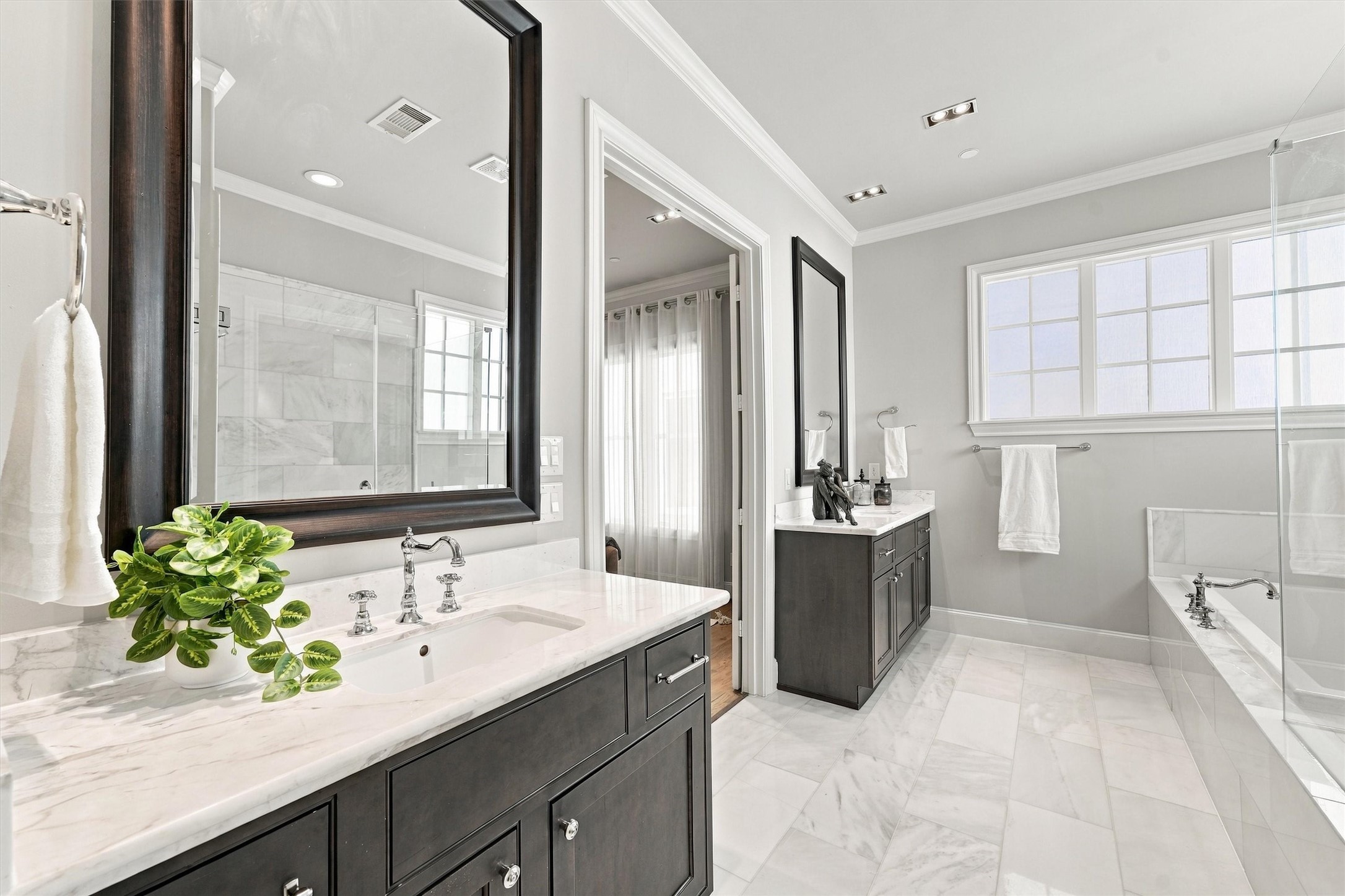 Primary bath with two separate vanities and a marble floor