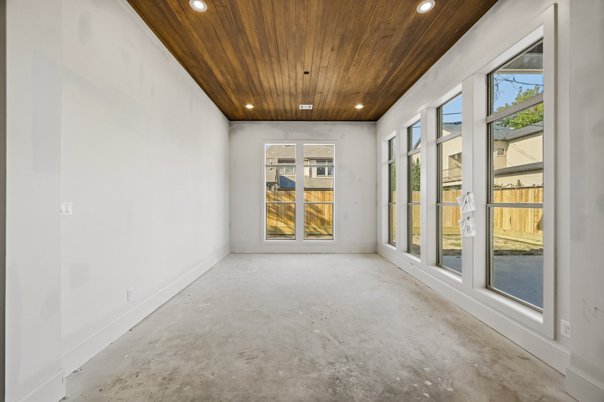 Bright, spacious dining room with large windows and a striking wood-paneled ceiling!