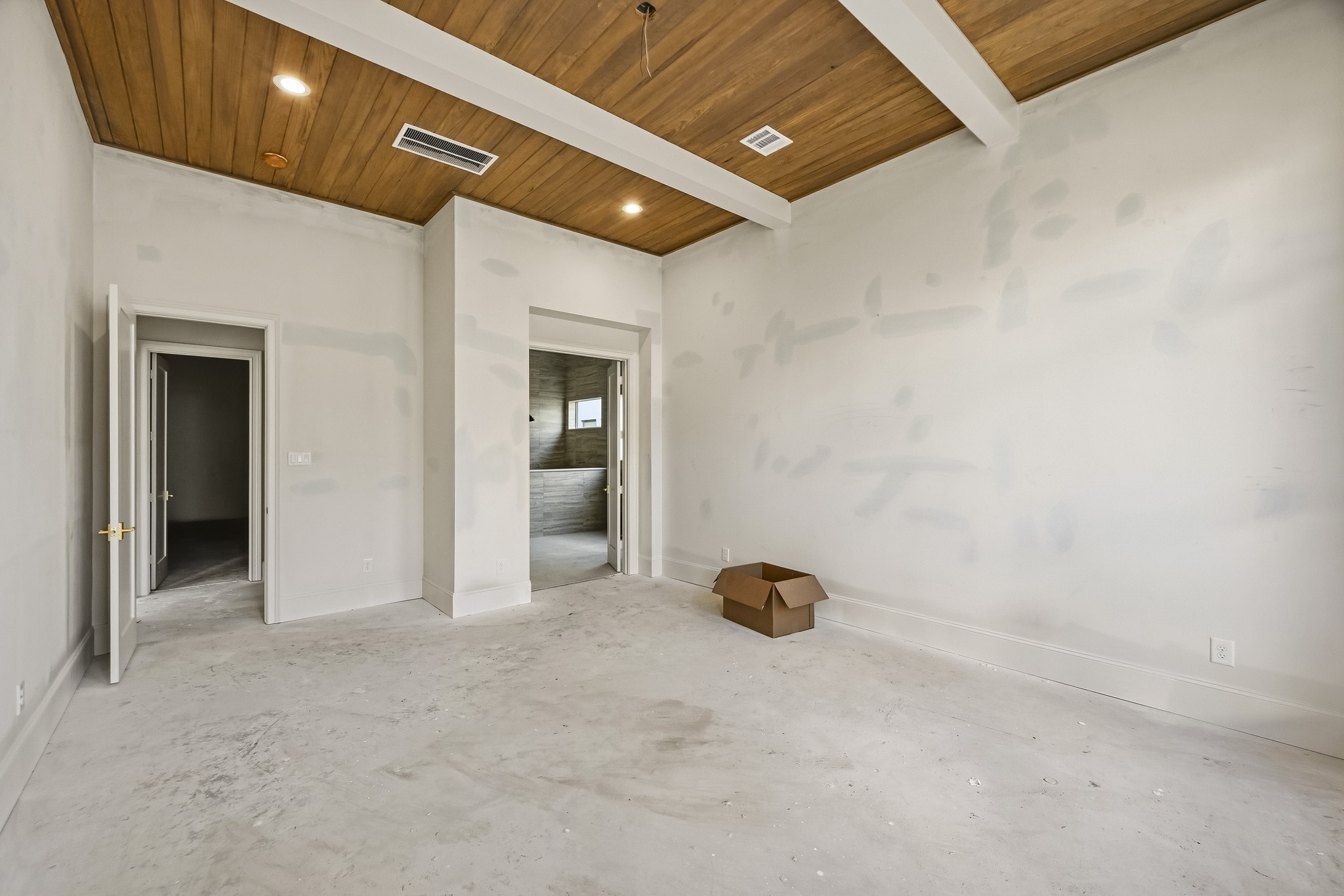 Spacious room with a warm wooden ceiling and recessed lighting, ready for your personal touch!
