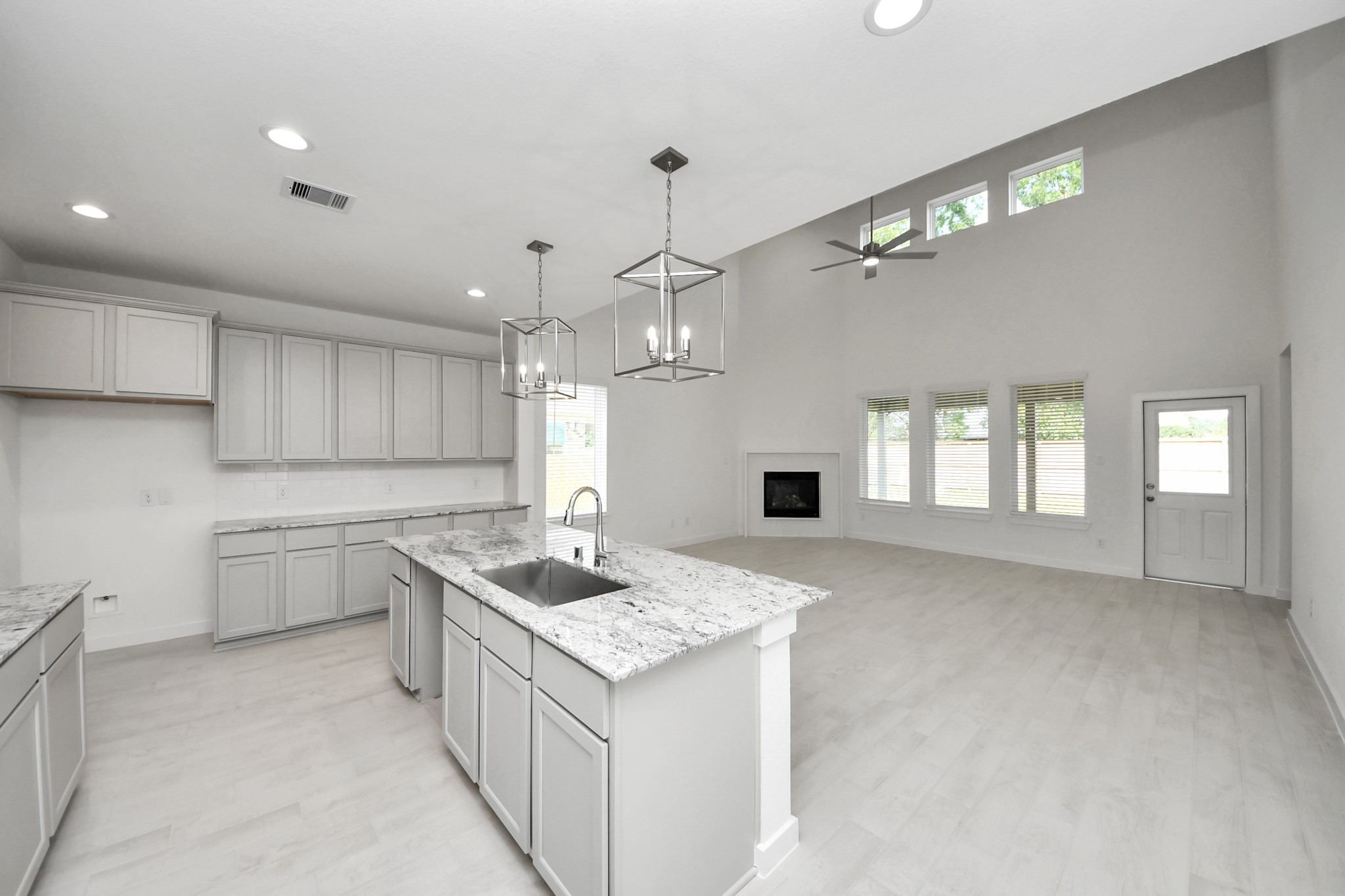 Step into a dream realized with this generously spacious kitchen! A massive granite island takes center stage, complemented by high ceilings and soft-close cabinets. The granite countertops, stainless steel appliances, sleek tile backsplash, and recessed lighting complete the elegant design. Sample photo of completed home with similar floor plan. Actual colors and selections may vary.