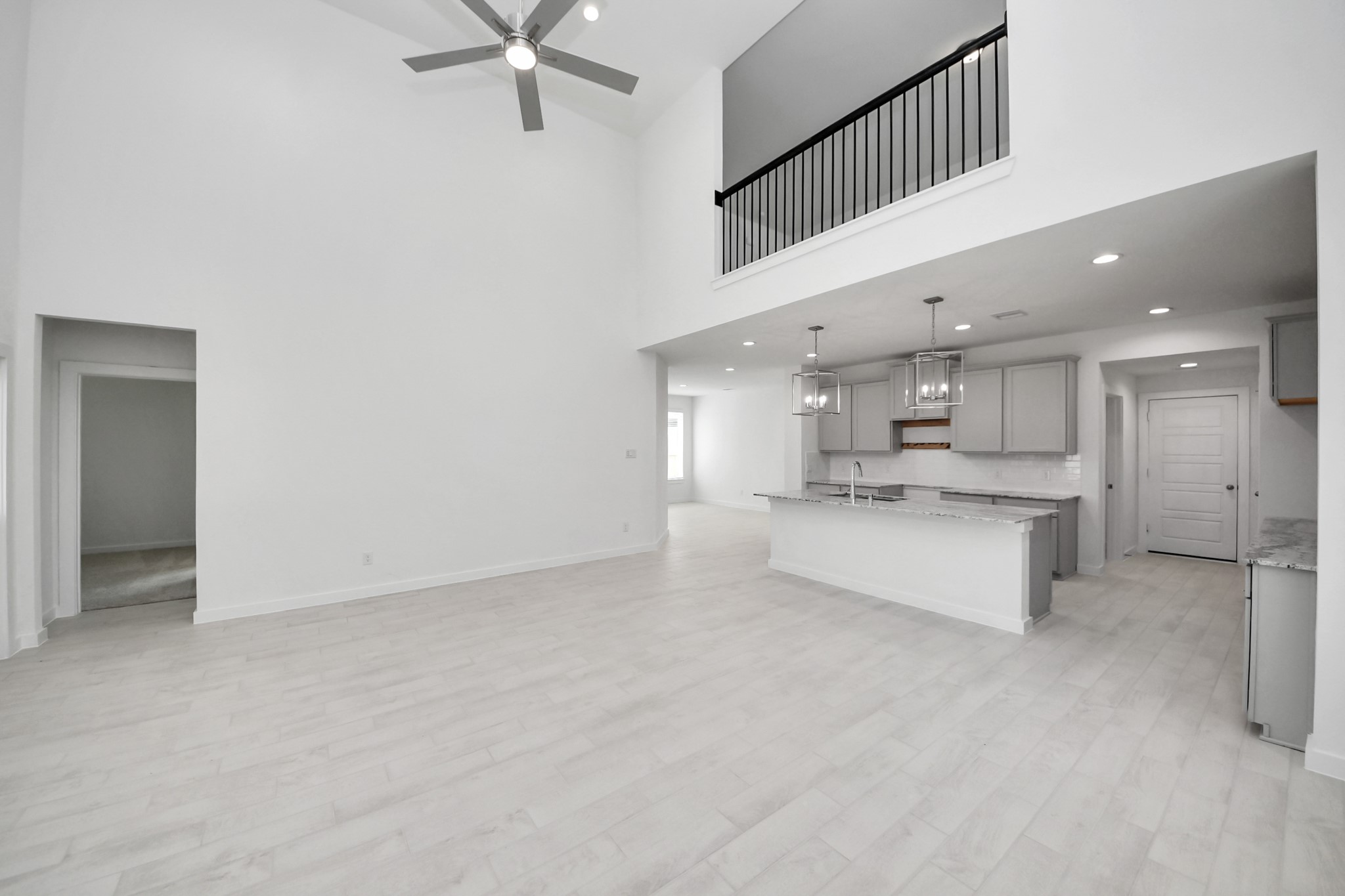 Welcome family and guests to your charming living room! With its high ceilings, recessed lighting, ceiling fan, custom paint, beautiful flooring, and large windows that let in abundant natural light, this room is perfect for gatherings. Sample photo of completed home with similar floor plan. Actual colors and selections may vary.