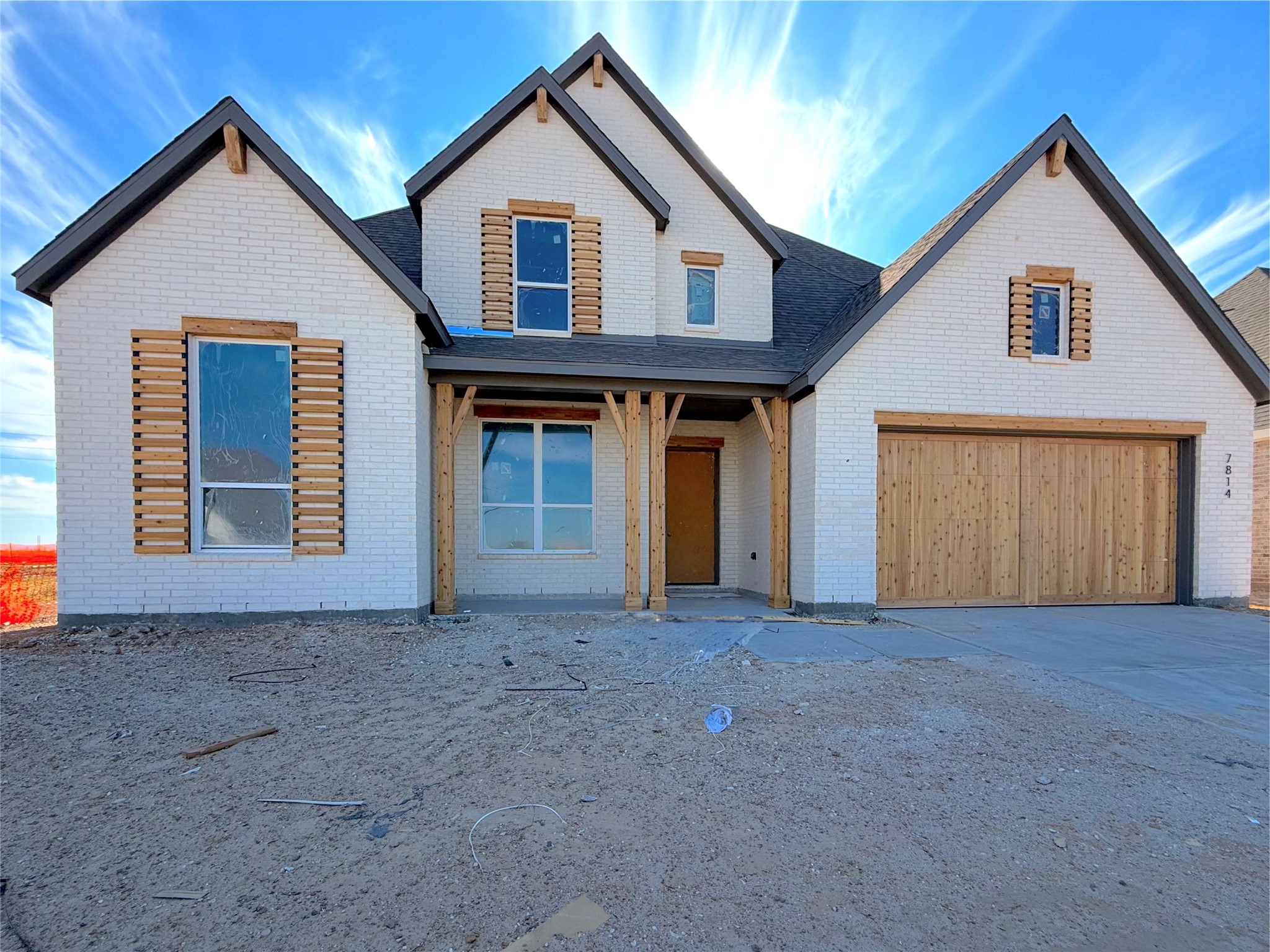 Classic ivory brick elevation with charming architectural details and a welcoming front porch Classic ivory brick elevation with charming architectural details and a welcoming front porch