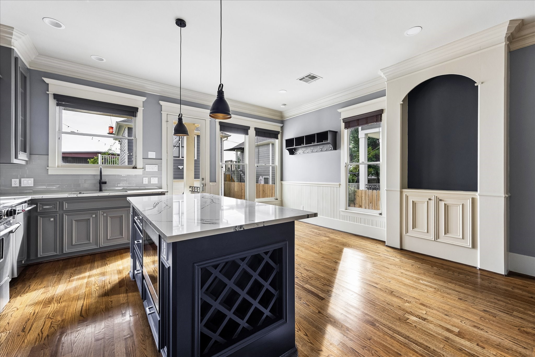 Decorative lattice wine storage adds a custom touch to the island, while generous windows brighten the adjoining breakfast area.