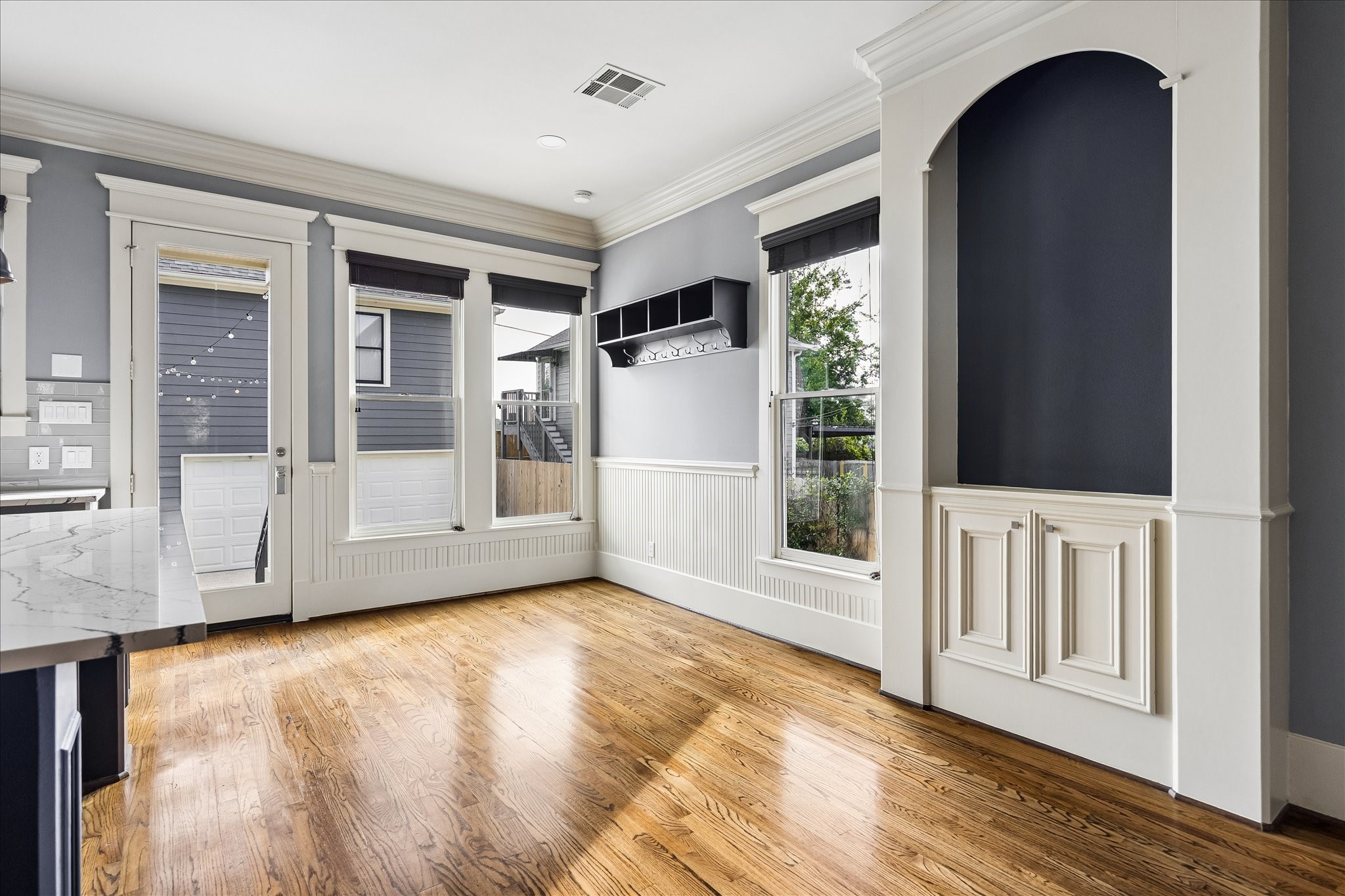 Tall windows, classic beadboard detailing, and an arched built-in lend charm and character to the sunlit breakfast area. Tall windows, classic beadboard detailing, and an arched built-in lend charm and character to the sunlit breakfast area.