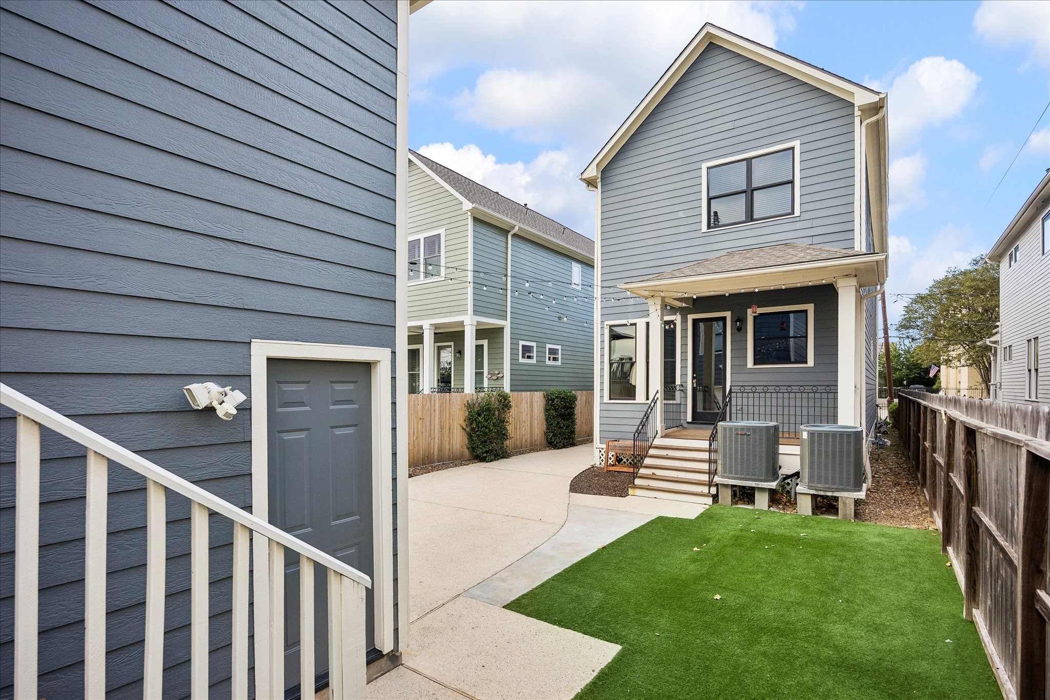 From the opposite perspective, the courtyard connects the main residence and detached garage, creating a practical and inviting outdoor setting.