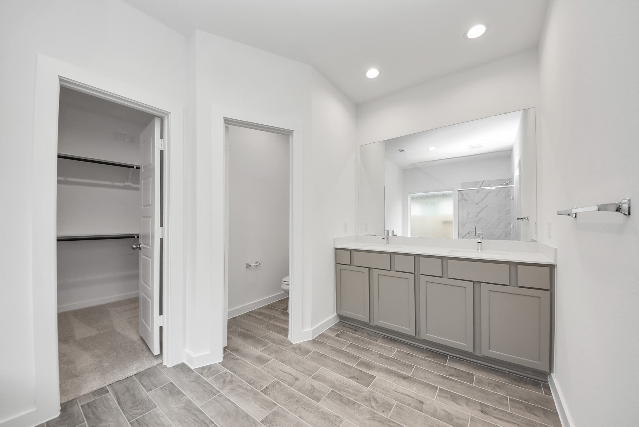 Escape to a spa-like oasis in this primary bathroom. Enjoy a walk-in shower with tile surround, a separate garden tub with custom detailing, and an elegant vanity featuring light countertops, modern hardware, and beautiful vanity lights. Experience luxury and relaxation in every detail.
