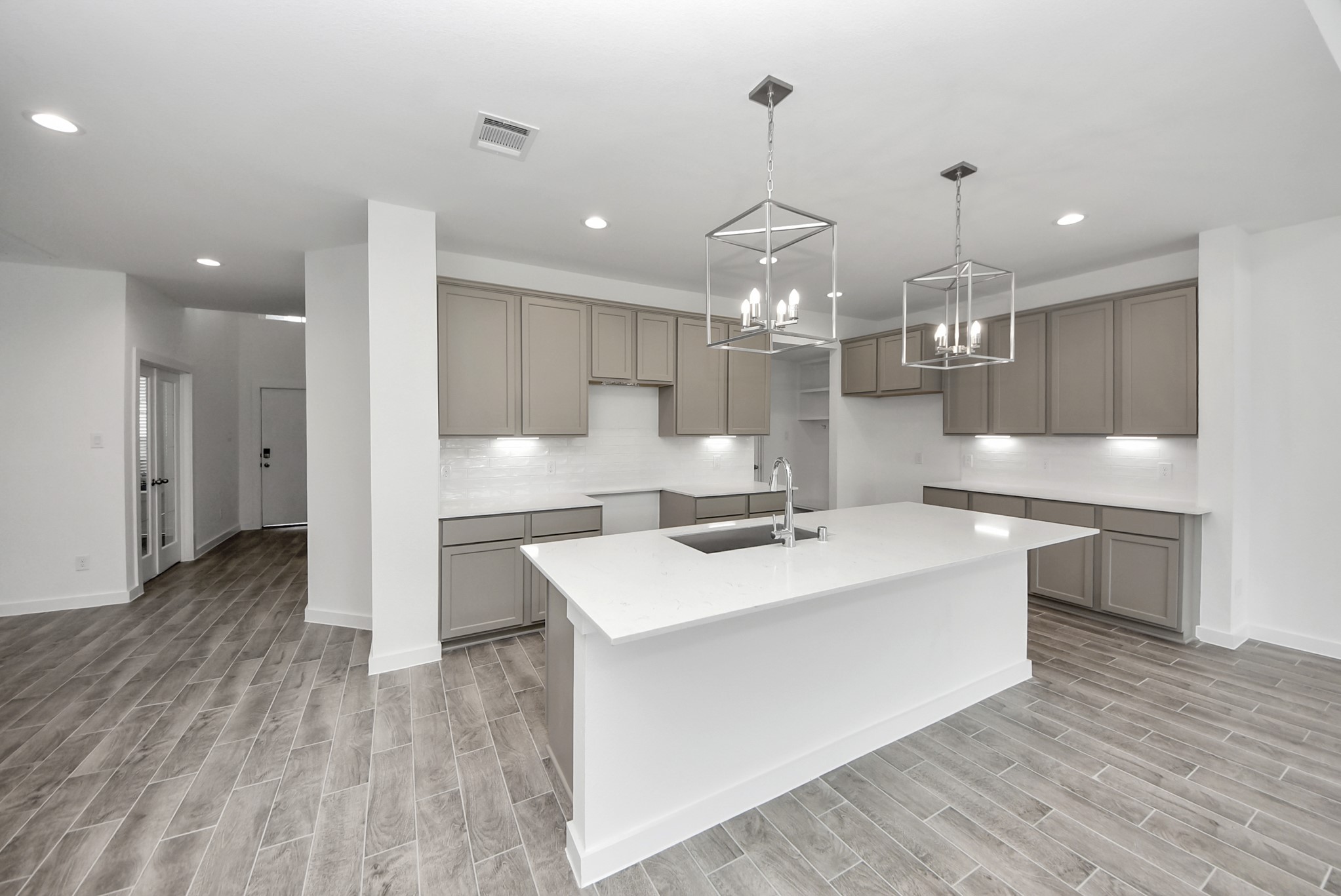 This kitchen is by far any chefs dream! This spacious kitchen features high ceilings, stained wood cabinets, granite countertop, SS appliances, modern tile backsplash, recessed lighting, extended counter space, granite kitchen island with double sink, and space for breakfast bar, and a walk-in pantry all overlooking your huge family room.